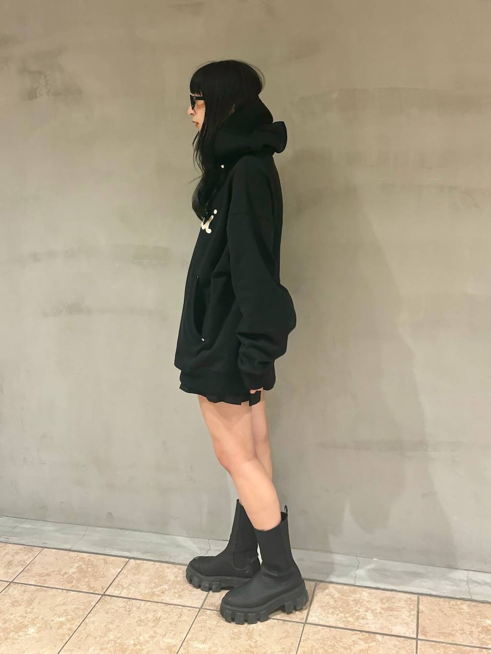 ブラック系のパーカー、ブラック系のブーツ、ブラック系のその他パンツを着用したレディースの冬コーディネートの3枚目の写真