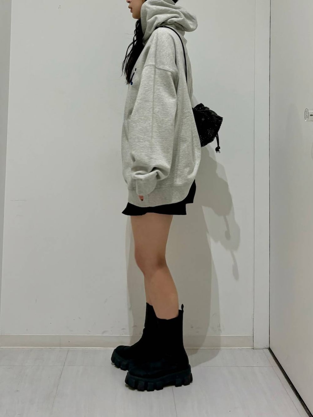 グレー系のパーカー、ブラック系のブーツ、ブラック系のその他パンツを着用したレディースの冬コーディネートの3枚目の写真