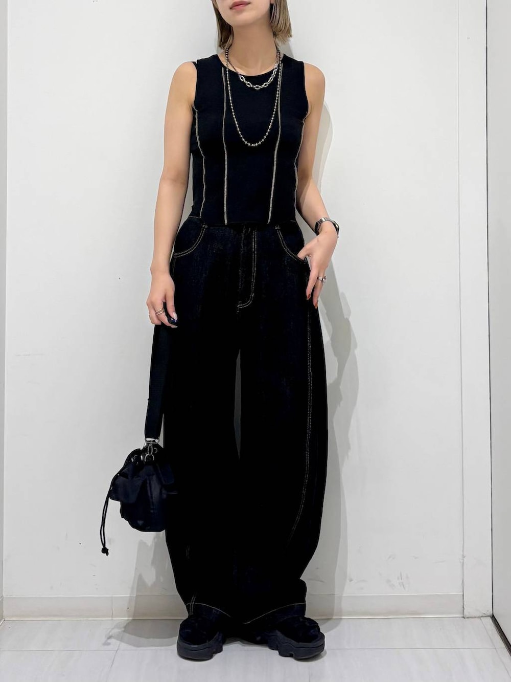 ブラック系のショルダーバッグ、ブラック系のデニムパンツ、ブラック系のタンクトップを着用したレディースの夏コーディネートの3枚目の写真