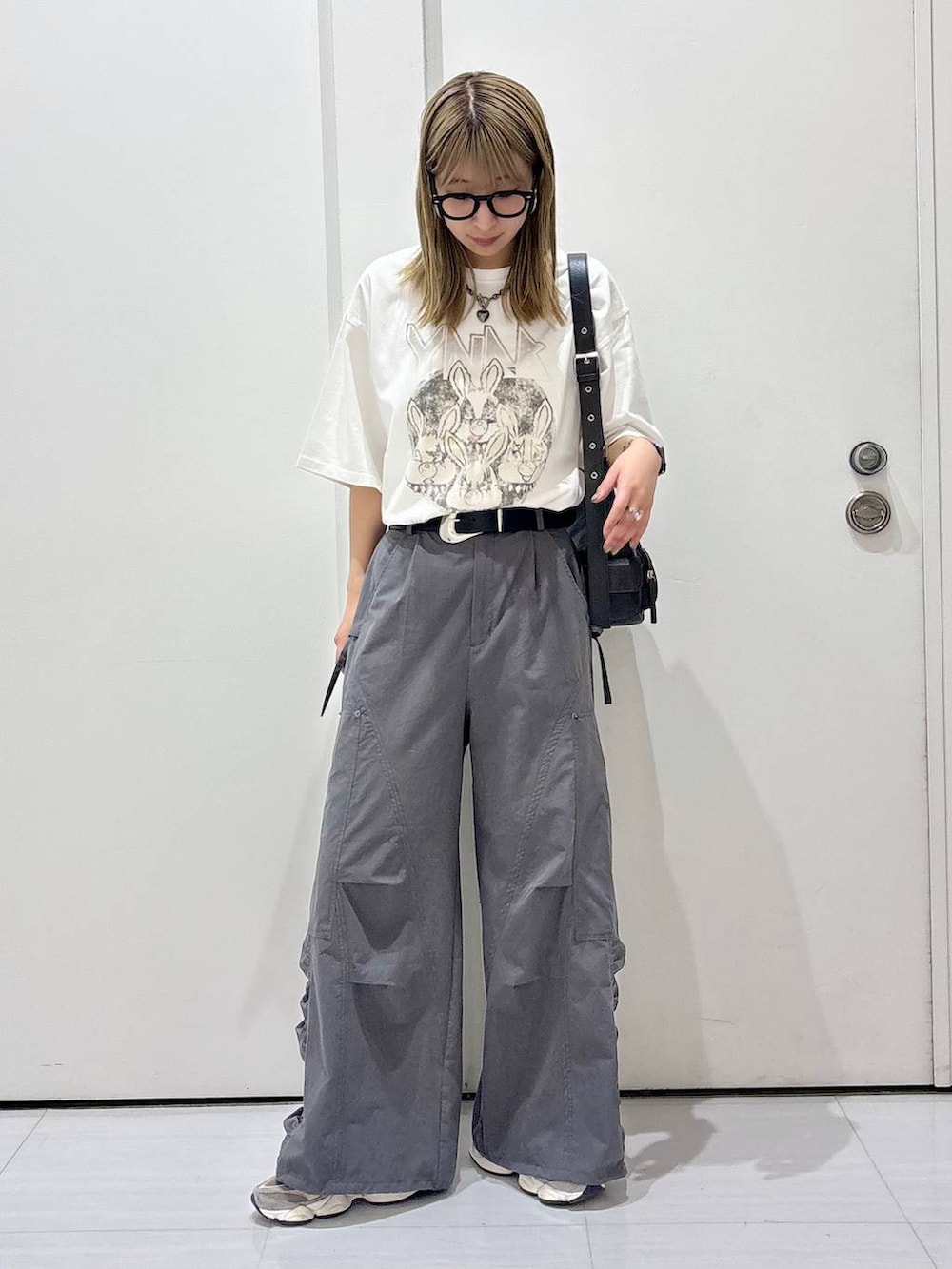 ブラック系のショルダーバッグ、グレー系のカーゴパンツ、ホワイト系のTシャツ/カットソーを着用したレディースの春コーディネートの2枚目の写真