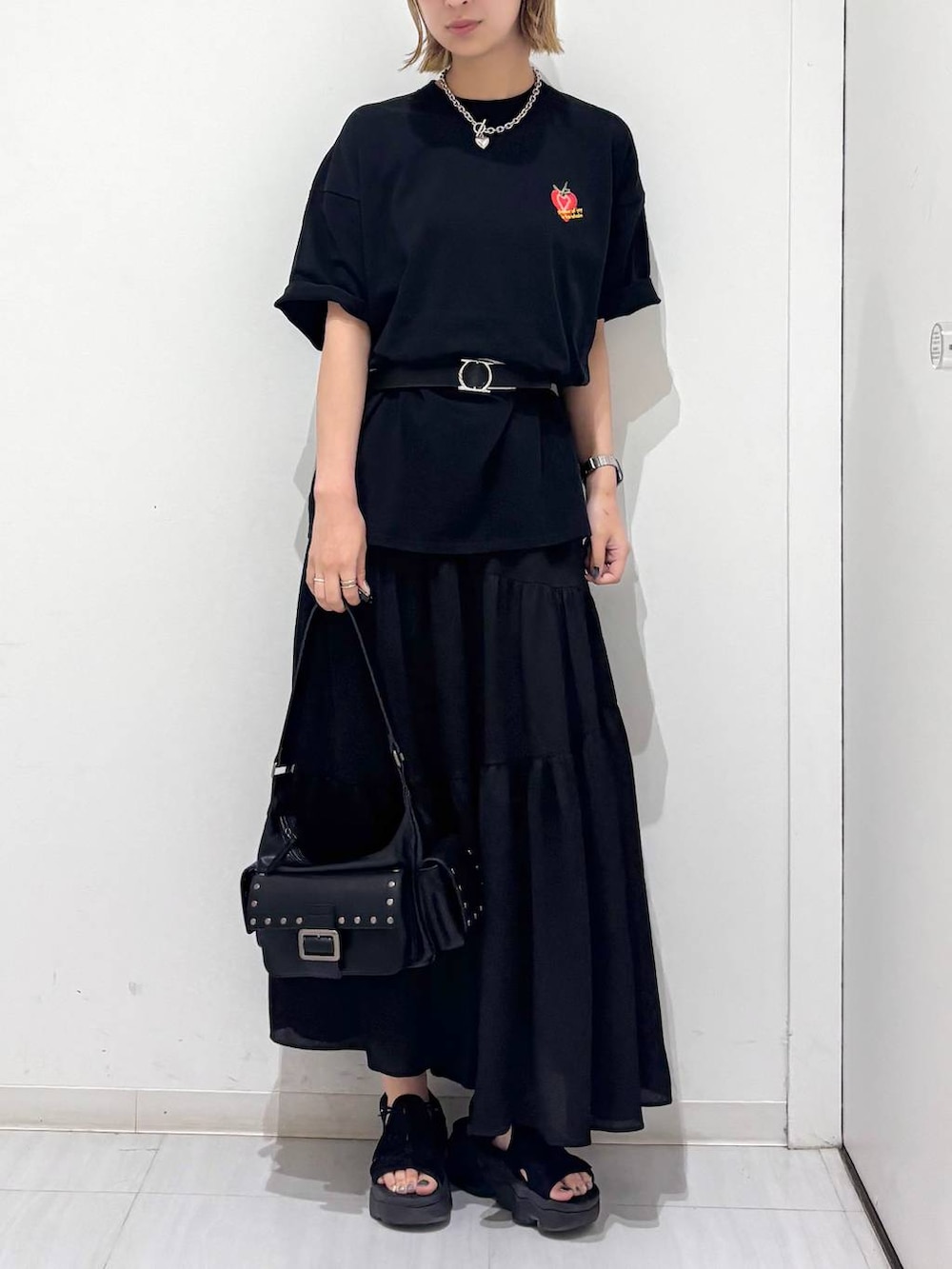 ブラック系のTシャツ/カットソー、ブラック系のスカート、ブラック系のショルダーバッグを着用したレディースの夏コーディネートの3枚目の写真