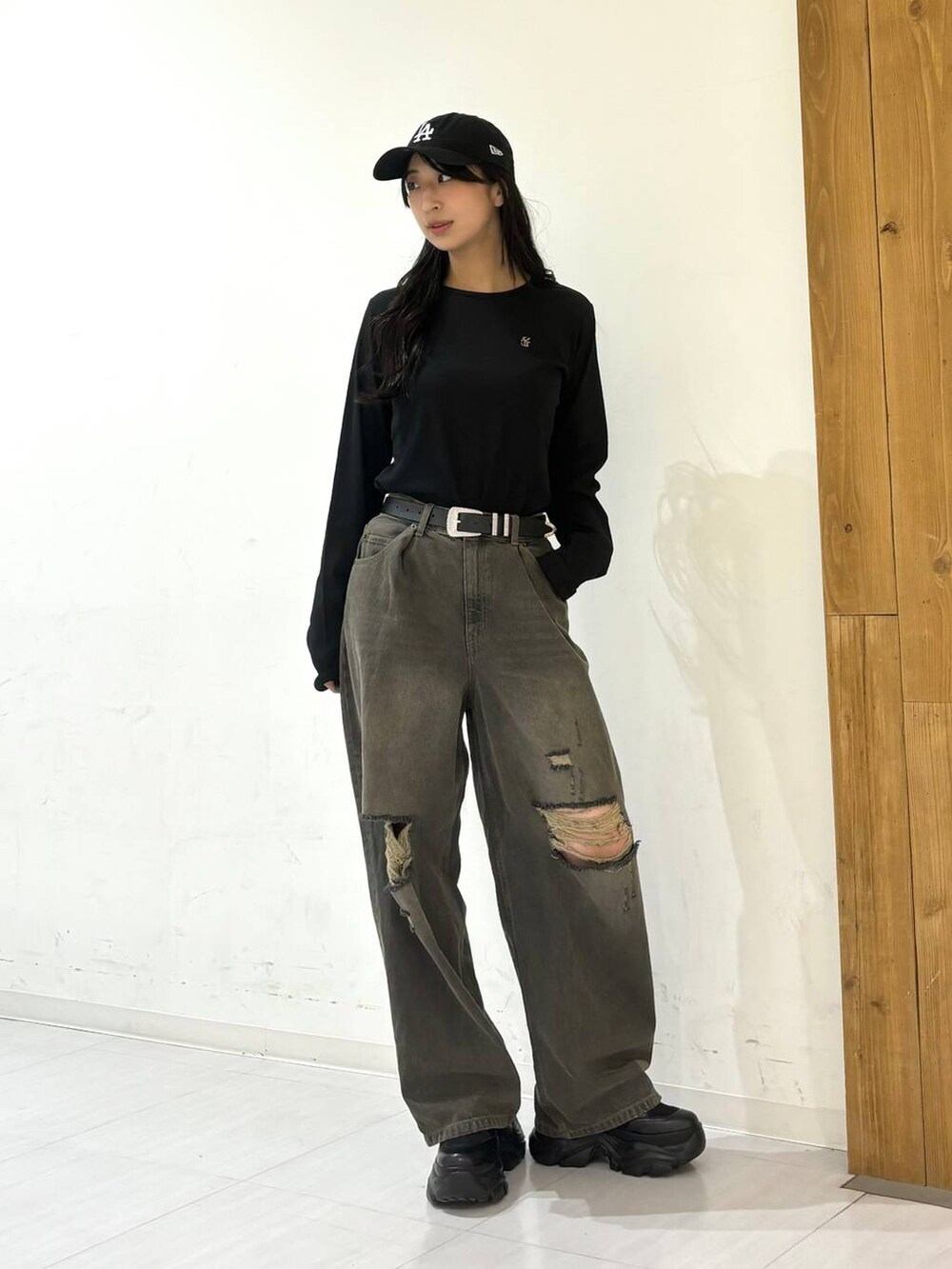 ブラック系のスニーカー、ブラック系のデニムパンツ、ブラック系のTシャツ/カットソーを着用したレディースの秋コーディネートの4枚目の写真