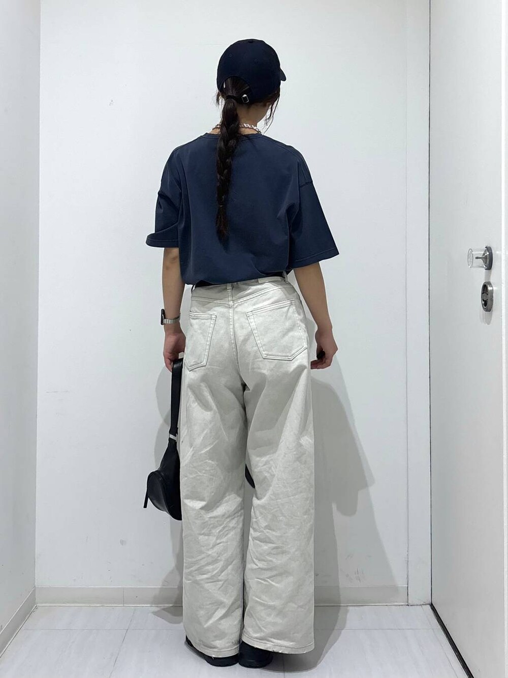 グレー系のデニムパンツ、ブラック系のスニーカー、ブルー系のTシャツ/カットソーを着用したレディースの春コーディネートの4枚目の写真