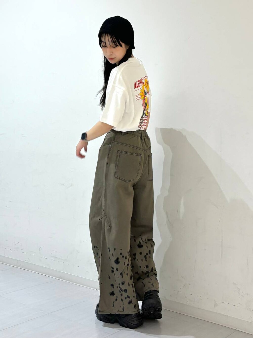 ブラック系のスニーカー、ホワイト系のTシャツ/カットソー、ブラック系のデニムパンツを着用したレディースの夏コーディネートの5枚目の写真