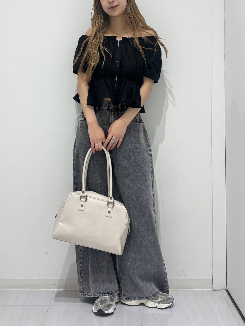 ホワイト系のボストンバッグ、ブラック系のデニムパンツ、ブラック系のシャツ/ブラウスを着用したレディースの春コーディネートの5枚目の写真