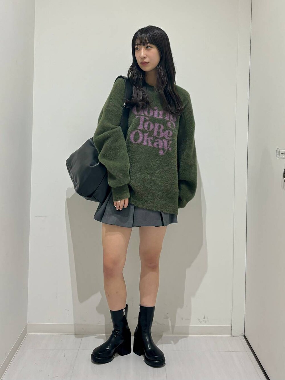 ブラック系のブーツ、グリーン系のニット/セーター、ブラック系のショルダーバッグを着用したレディースの秋コーディネートの5枚目の写真