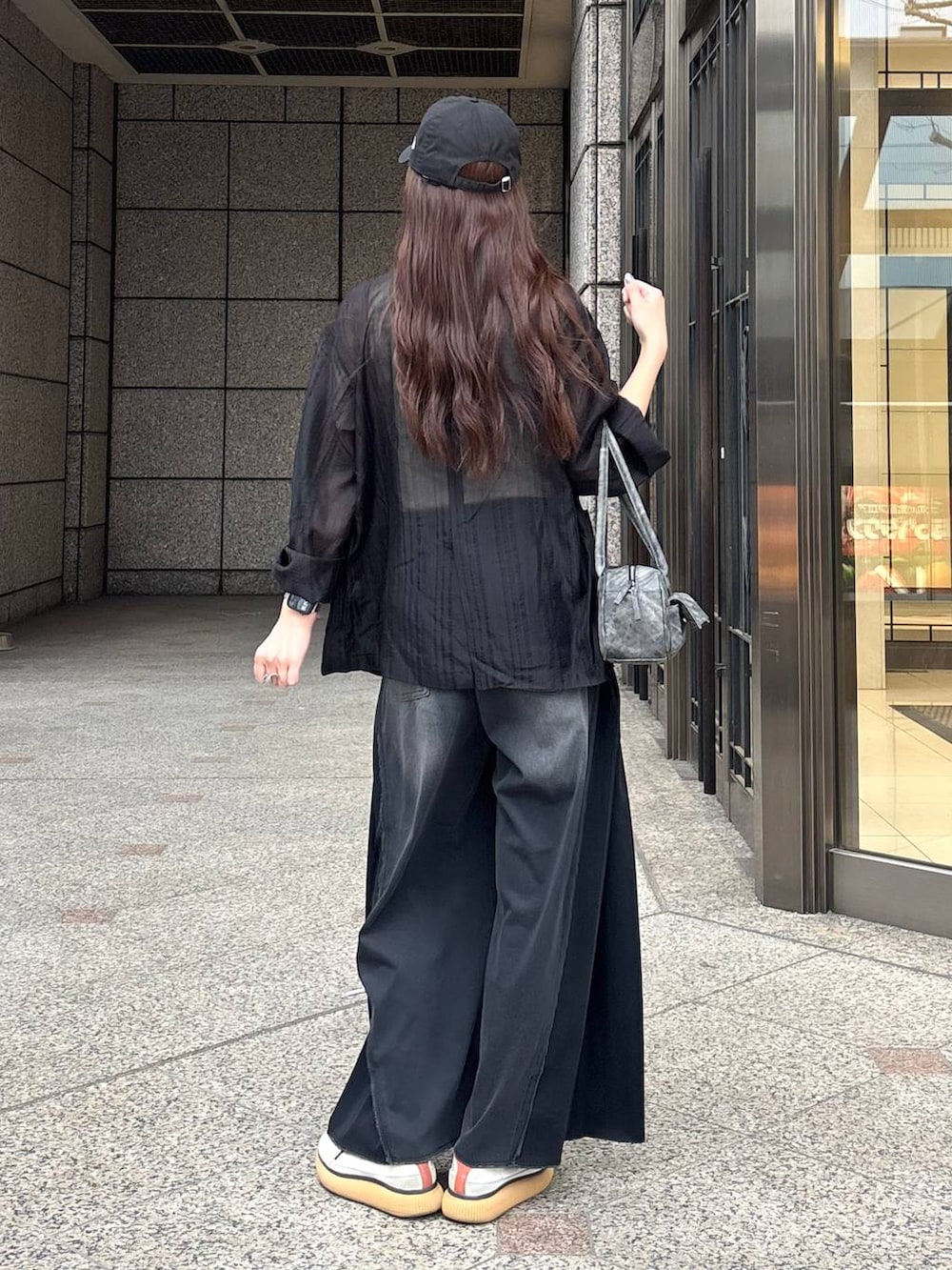 ブラック系のボストンバッグ、ホワイト系のタンクトップ、ブラック系のデニムパンツを着用したレディースの春コーディネートの4枚目の写真