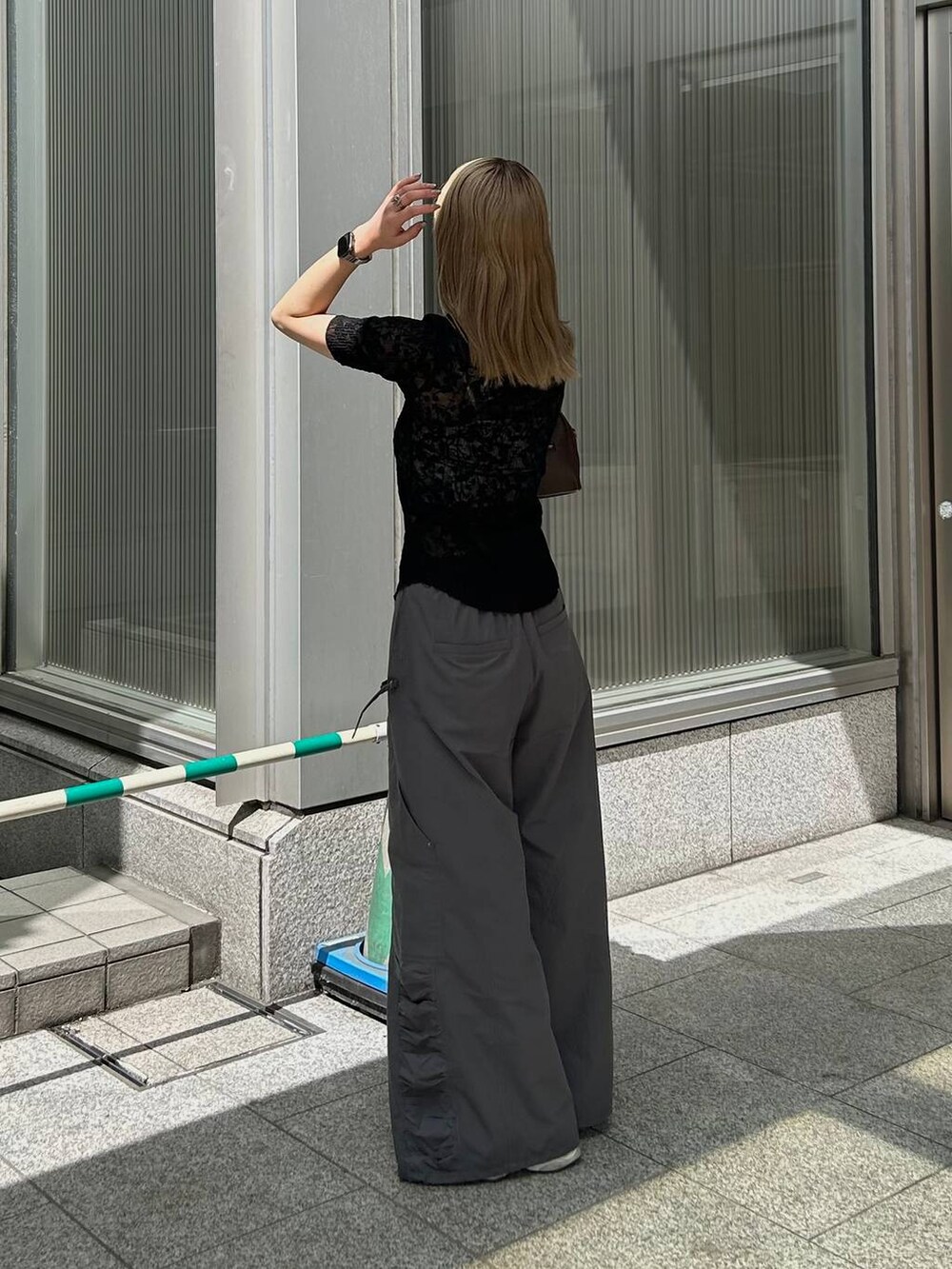 グレー系のカーゴパンツ、ブラウン系のショルダーバッグ、ブラック系のシャツ/ブラウスを着用したレディースの夏コーディネートの4枚目の写真