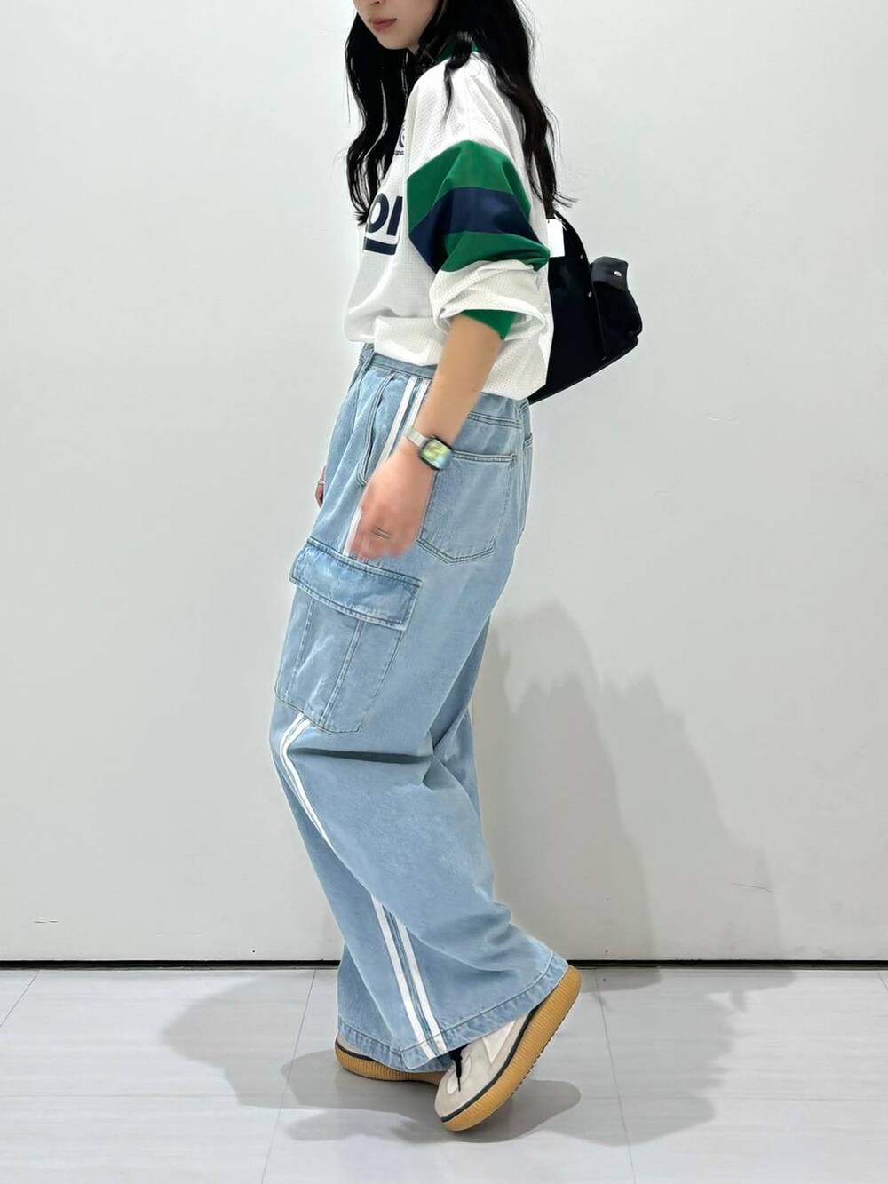 ブラック系のショルダーバッグ、ホワイト系のシャツ/ブラウス、ブルー系のデニムパンツを着用したレディースの春コーディネートの2枚目の写真