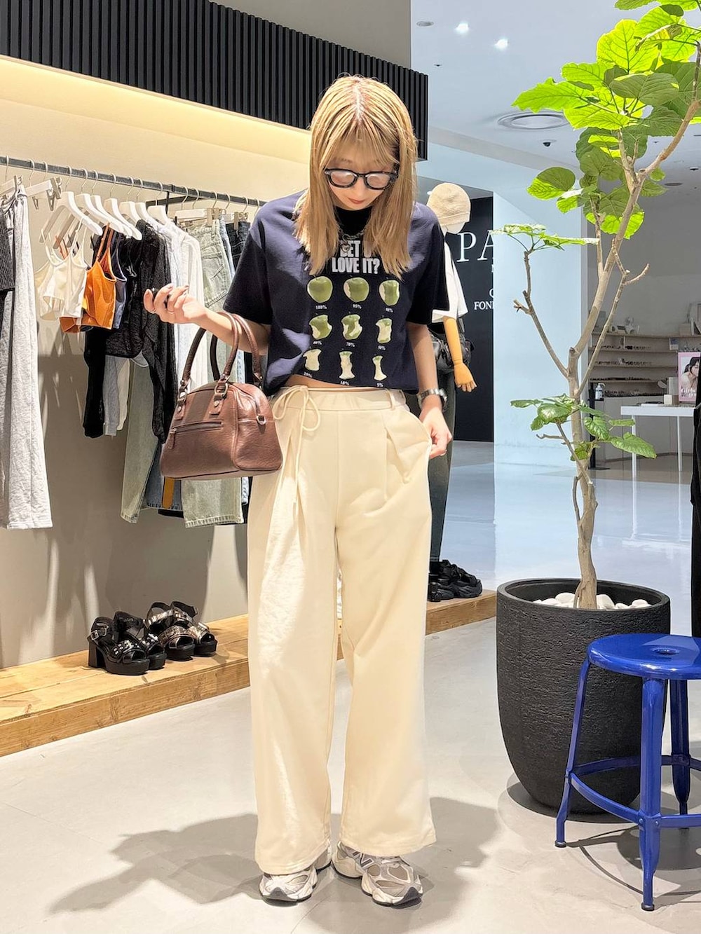 ブルー系のTシャツ/カットソー、ブラウン系のショルダーバッグ、ホワイト系のスウェットパンツを着用したレディースの夏コーディネートの2枚目の写真