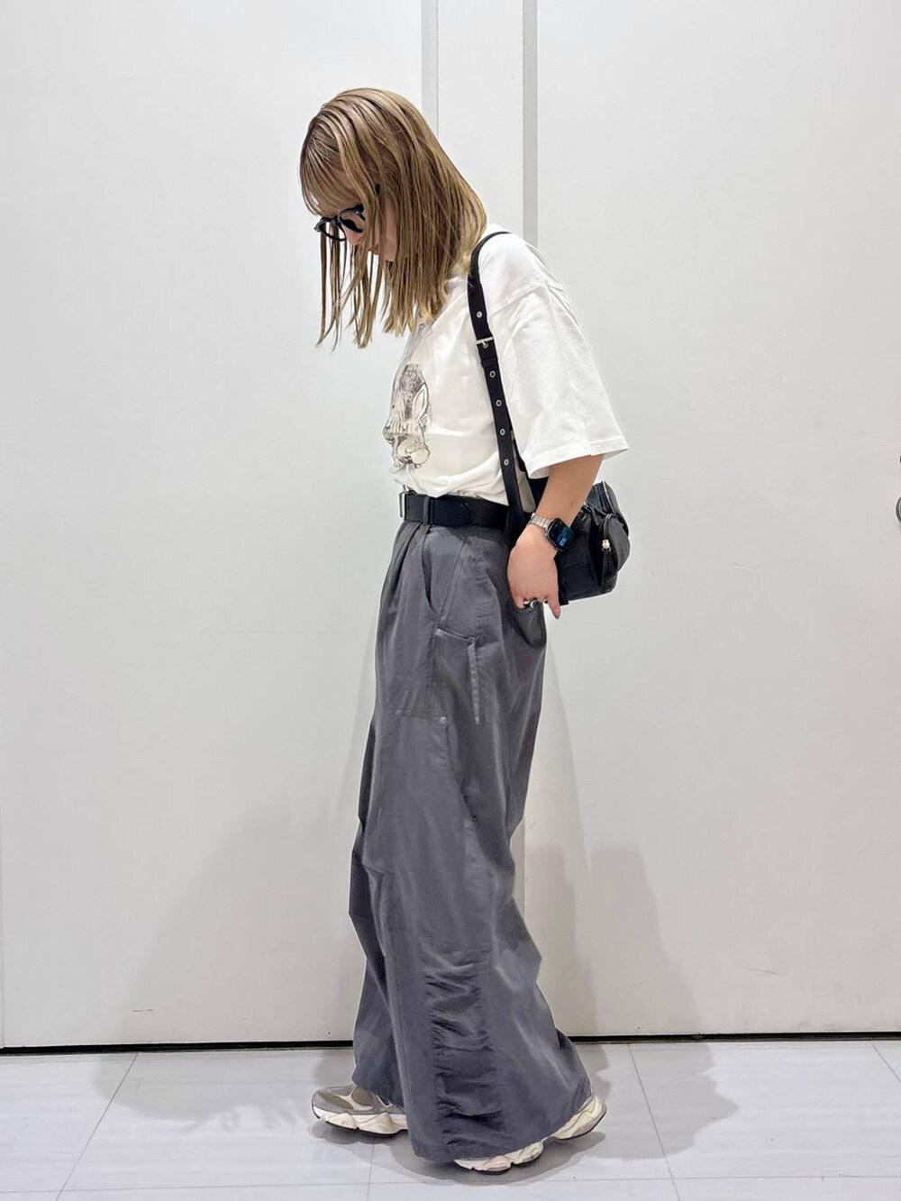 ブラック系のショルダーバッグ、グレー系のカーゴパンツ、ホワイト系のTシャツ/カットソーを着用したレディースの春コーディネートの4枚目の写真