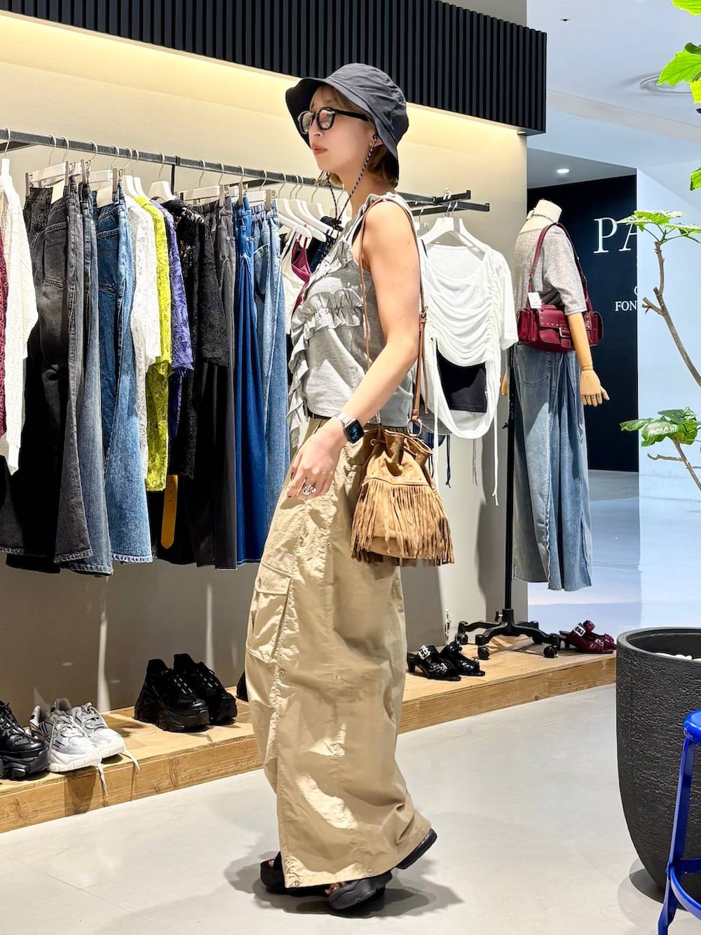 グレー系のタンクトップ、ベージュ系のカーゴパンツ、ブラック系のベルトを着用したレディースの夏コーディネートの4枚目の写真