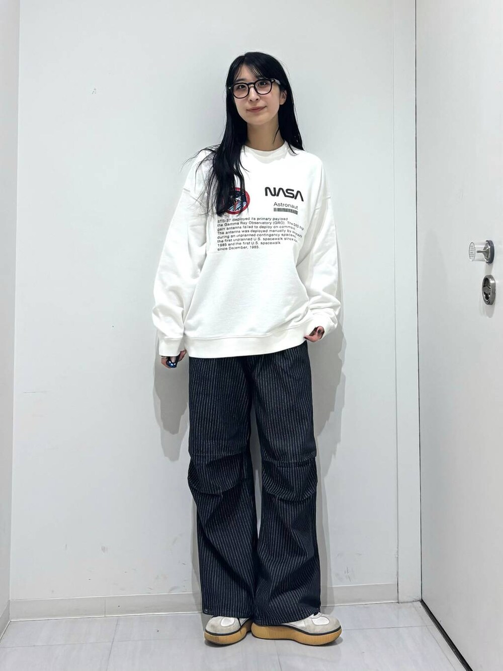 ブラック系のデニムパンツ、ホワイト系のスウェットを着用したレディースの秋コーディネートの3枚目の写真