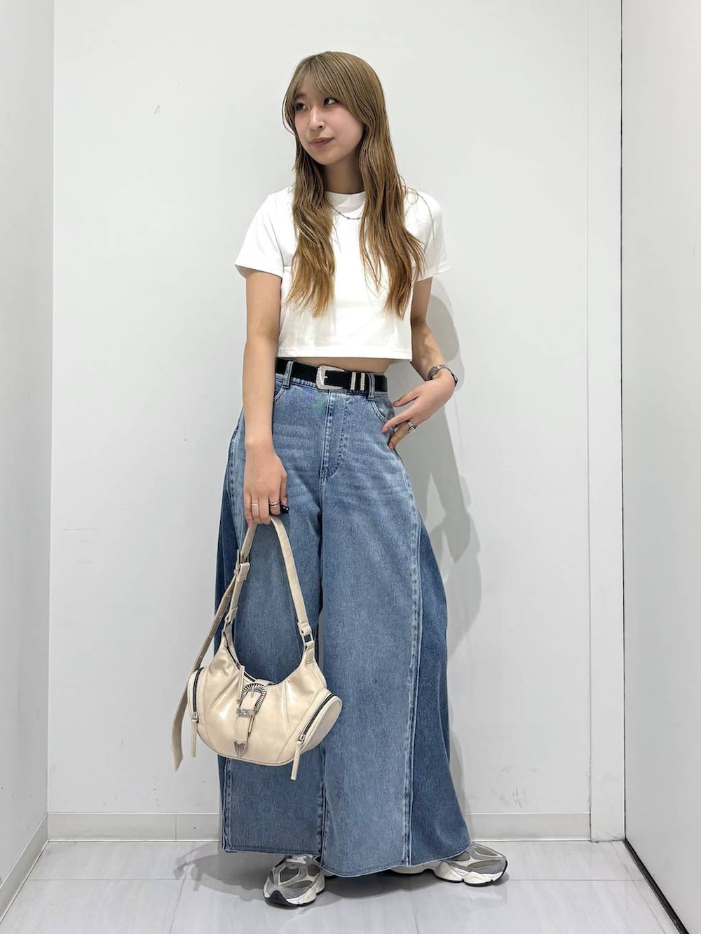 ホワイト系のショルダーバッグ、ブルー系のデニムパンツ、ホワイト系のTシャツ/カットソーを着用したレディースの春コーディネートの2枚目の写真