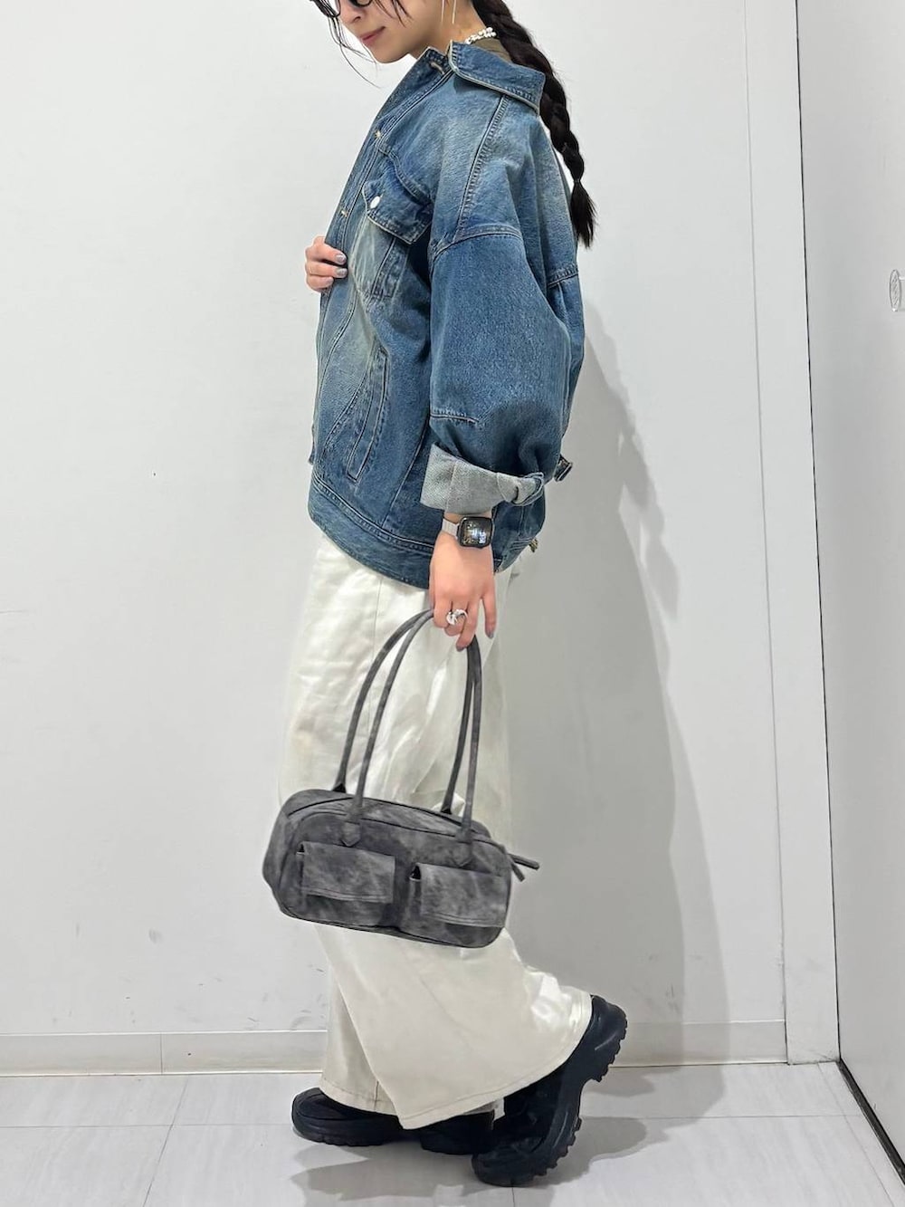 グレー系のデニムパンツ、ブラック系のスニーカー、ブルー系のデニムジャケットを着用したレディースの春コーディネートの4枚目の写真