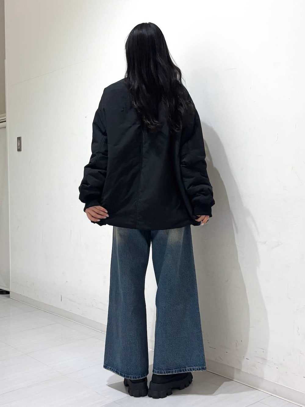 ブラック系のMA-1、ブルー系のデニムパンツを着用したレディースの冬コーディネートの3枚目の写真