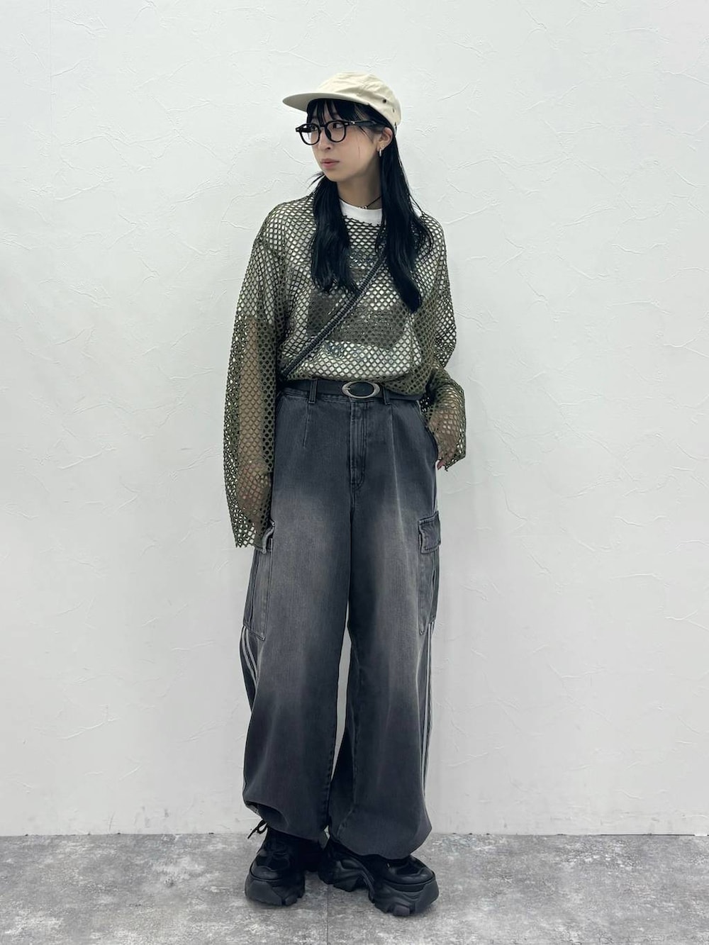 ブラック系のスニーカー、ブラック系のデニムパンツ、グリーン系のTシャツ/カットソーを着用したレディースの夏コーディネートの4枚目の写真