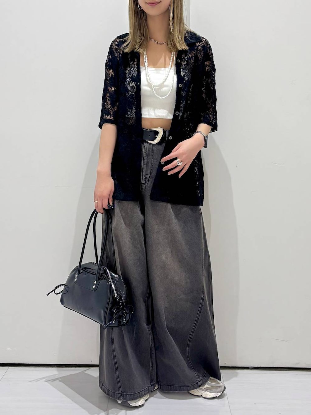 ブラック系のデニムパンツ、ブラック系のショルダーバッグ、ブラック系のシャツ/ブラウスを着用したレディースの春コーディネートの5枚目の写真