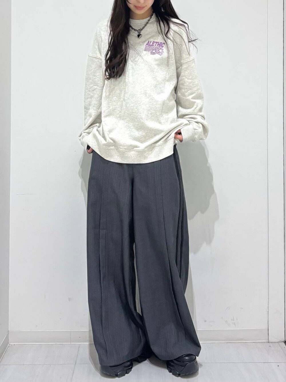 ブラック系のスニーカー、ベージュ系のスウェット、グレー系のスラックスを着用したレディースの冬コーディネートの4枚目の写真