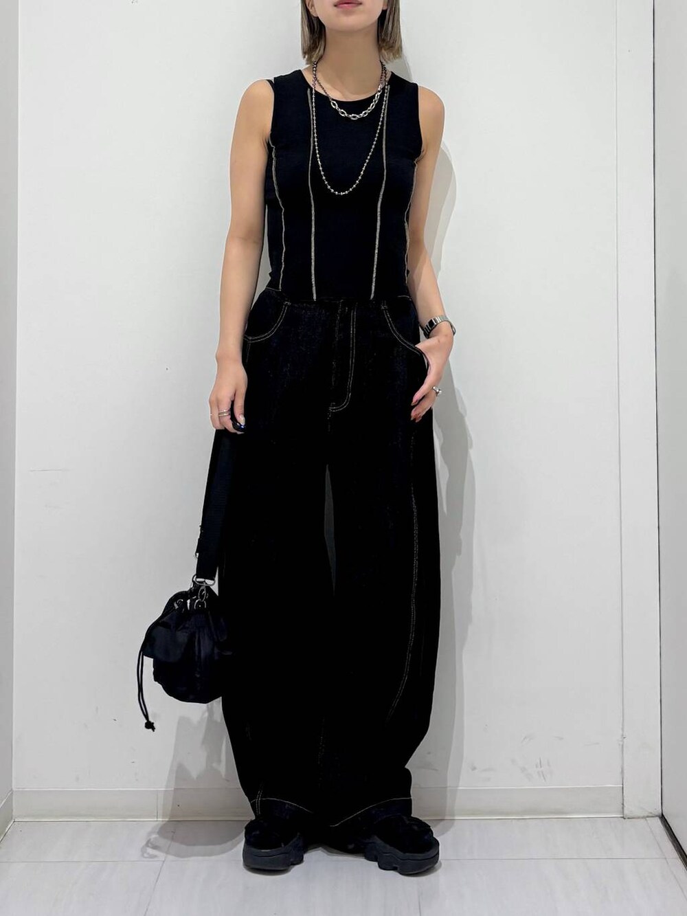 ブラック系のショルダーバッグ、ブラック系のデニムパンツ、ブラック系のタンクトップを着用したレディースの夏コーディネートの6枚目の写真