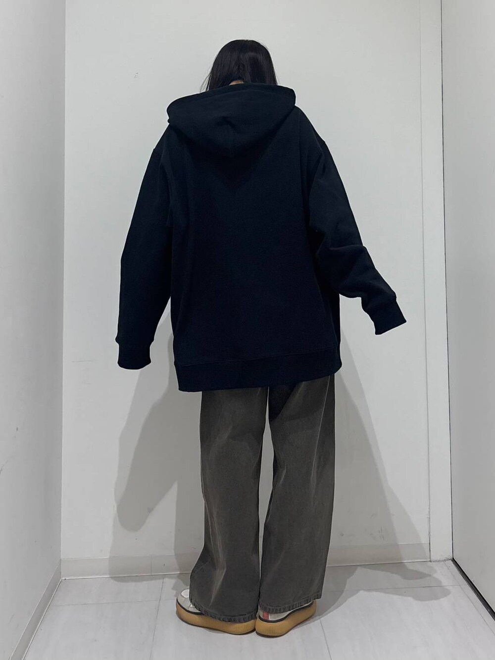 ブラック系のデニムパンツ、ブラック系のパーカーを着用したレディースの秋コーディネートの4枚目の写真