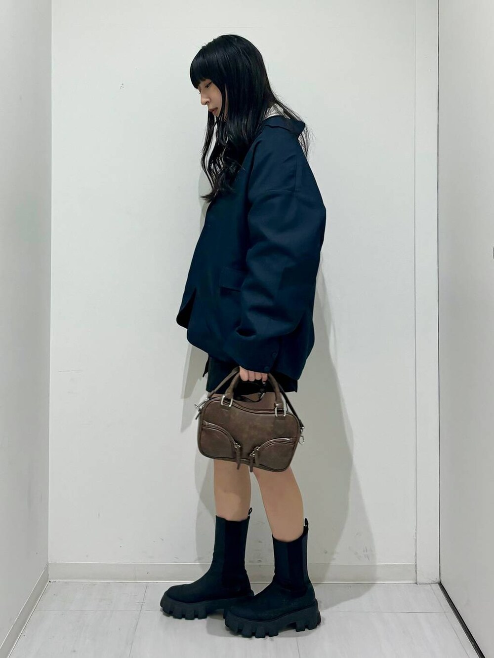 ブルー系のテーラードジャケット、ブラック系のスウェット、ブラック系のブーツを着用したレディースの冬コーディネートの3枚目の写真