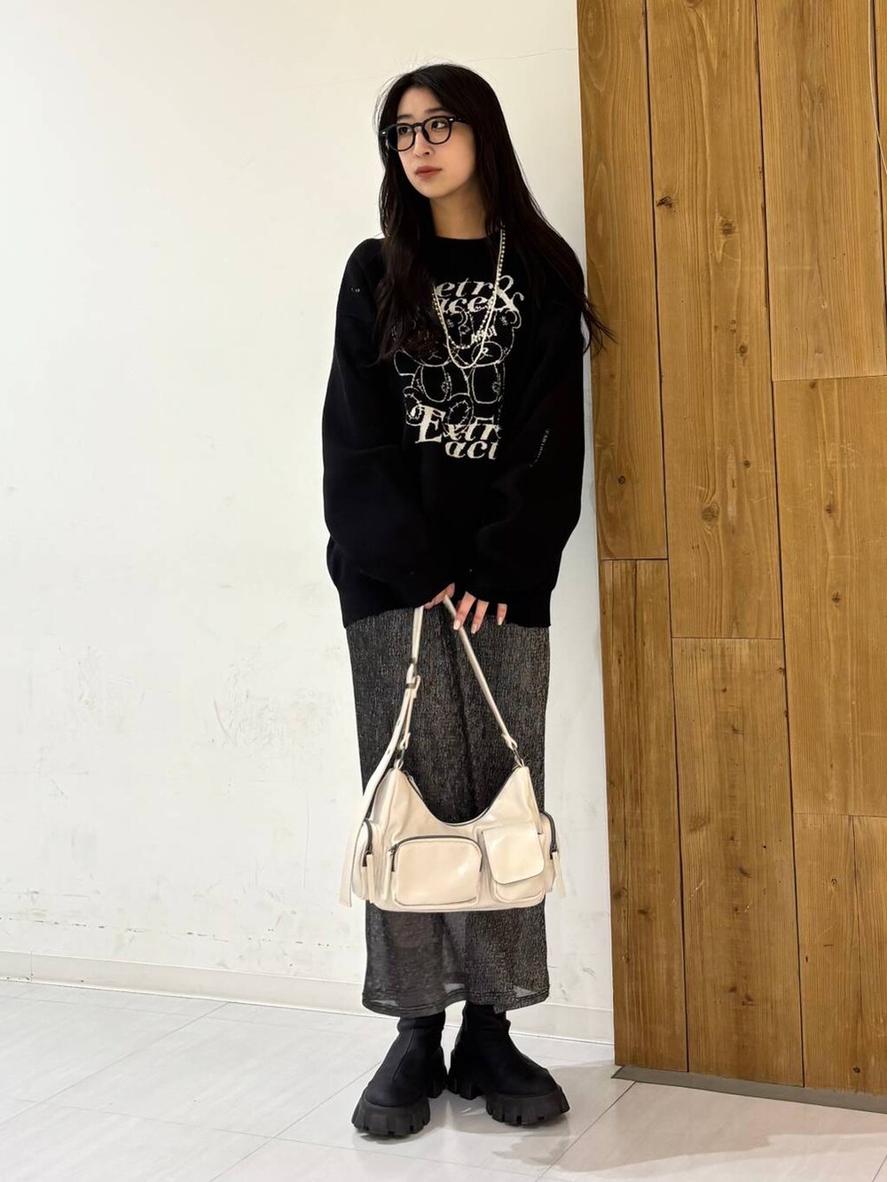 ホワイト系のショルダーバッグ、ブラック系のニット/セーター、ブラック系のスカートを着用したレディースの冬コーディネートの5枚目の写真