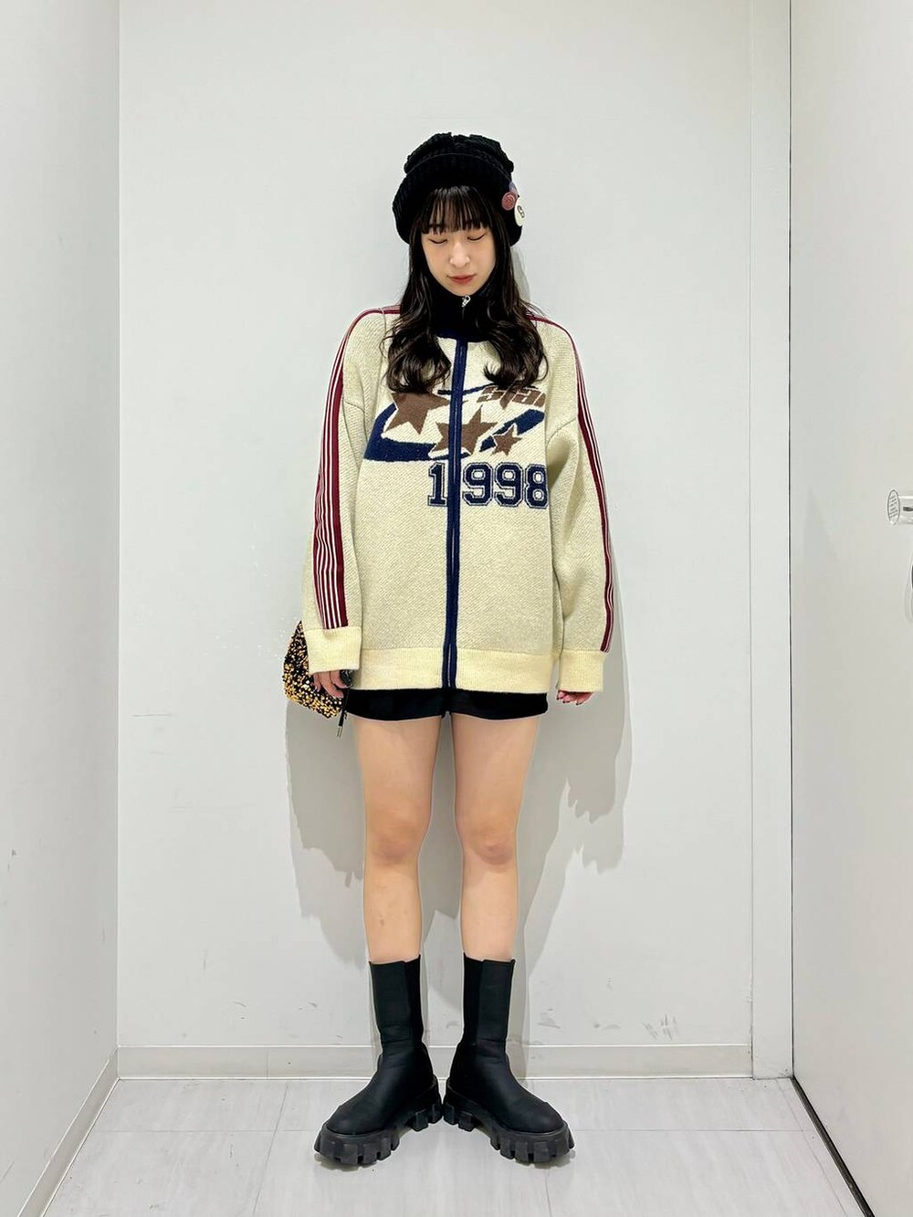 ブラック系のブーツ、ブラック系のその他パンツ、ゴールド系のショルダーバッグを着用したレディースの秋コーディネートの2枚目の写真