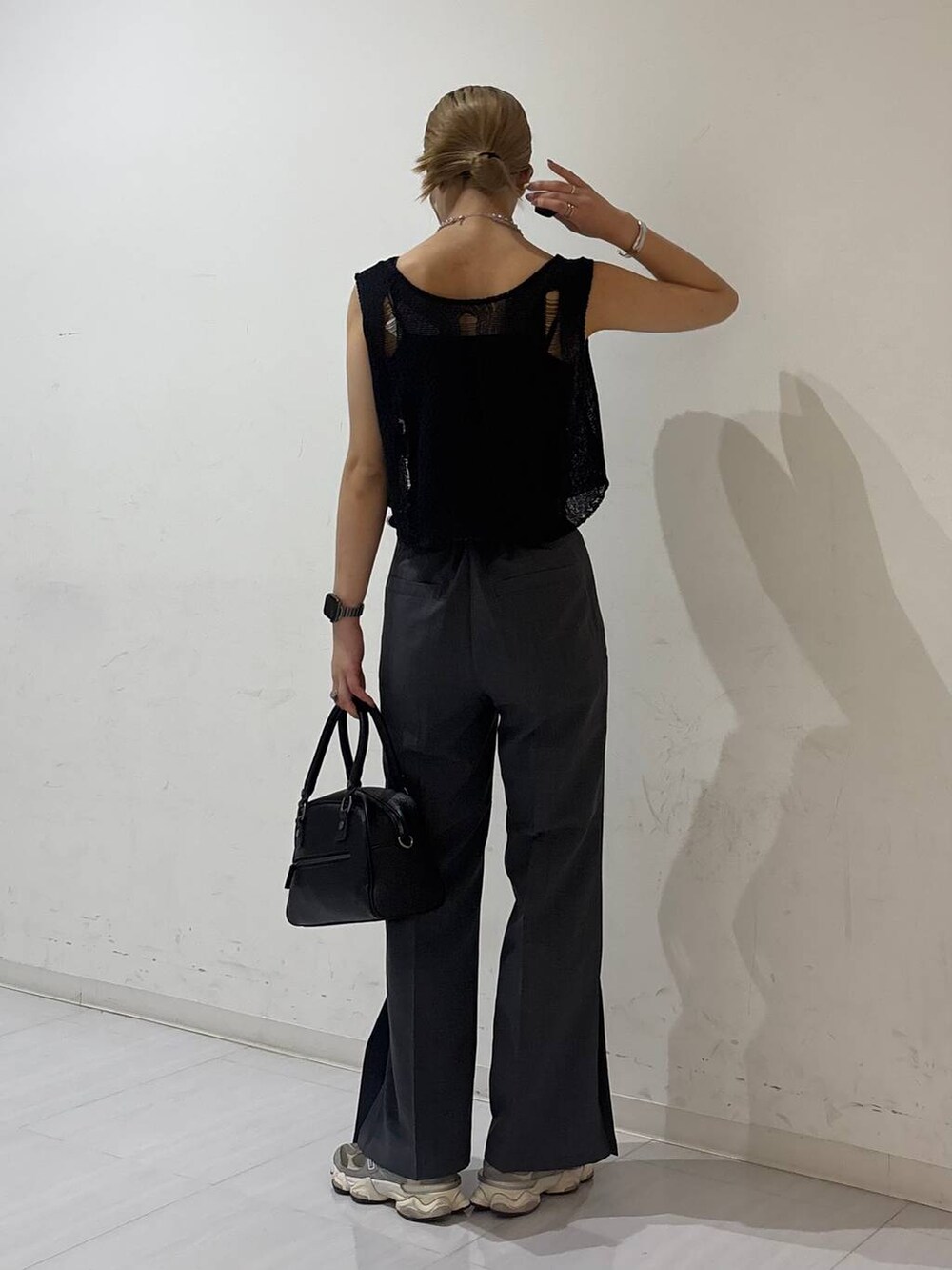 ブラック系のキャミソール、ブラック系のショルダーバッグ、ブラック系のベストを着用したレディースの夏コーディネートの4枚目の写真