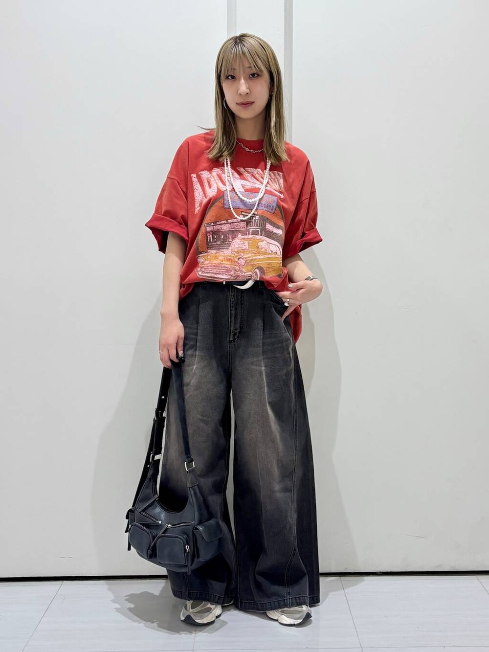 ブルー系のデニムパンツ、ブラック系のショルダーバッグ、レッド系のTシャツ/カットソーを着用したレディースの春コーディネートの2枚目の写真