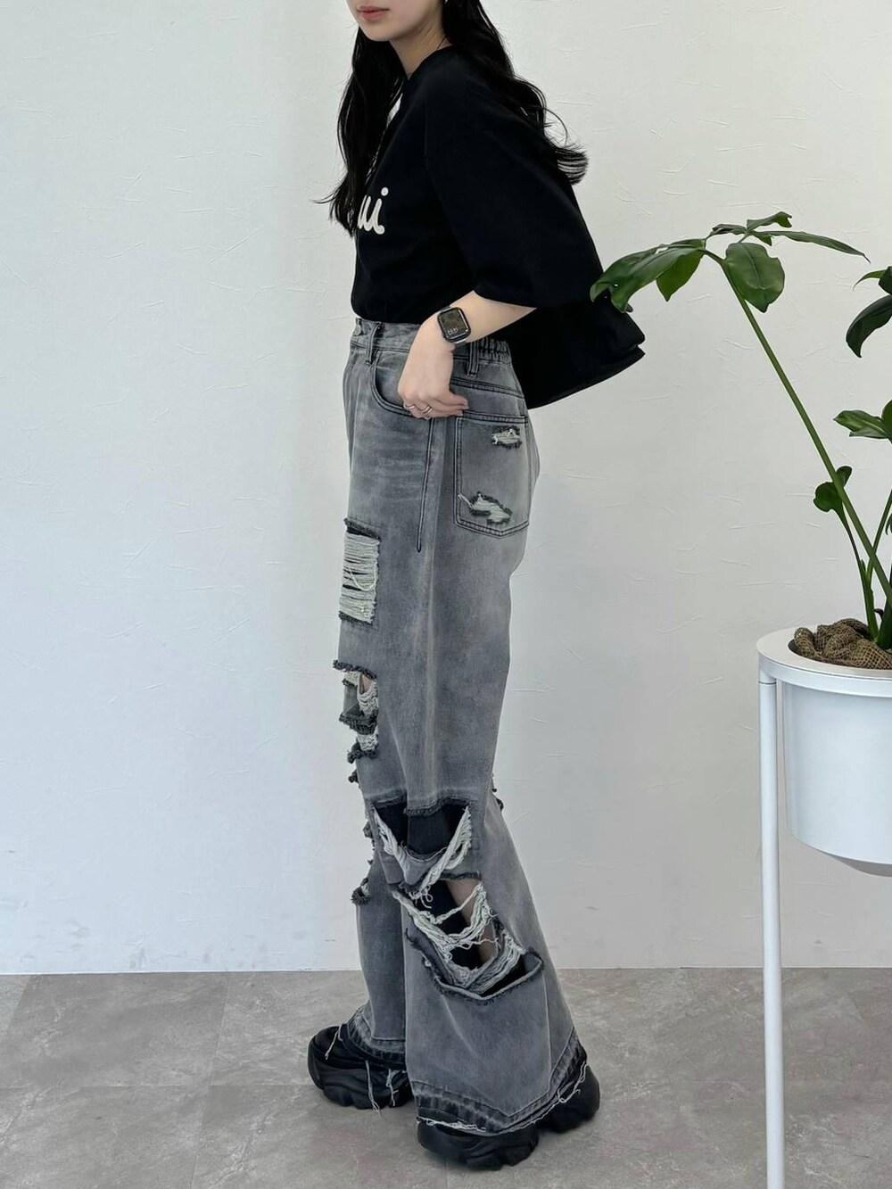 ブラック系のデニムパンツ、ブラック系のスニーカー、ブラック系のTシャツ/カットソーを着用したレディースの春コーディネートの4枚目の写真