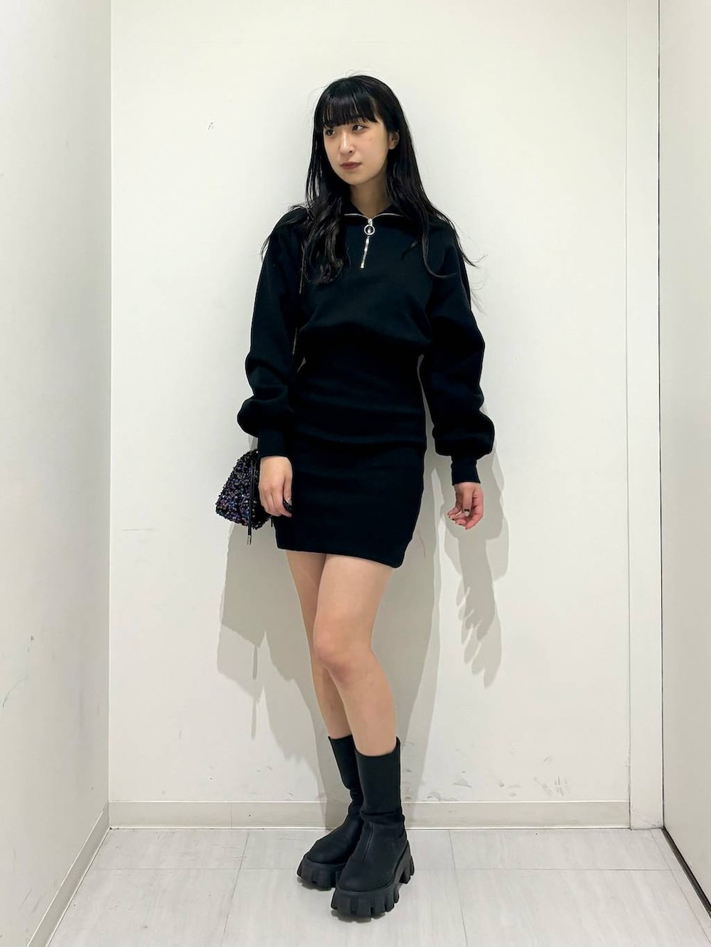 ブラック系のワンピース、ブラック系のブーツ、ブラック系のショルダーバッグを着用したレディースの冬コーディネートの6枚目の写真