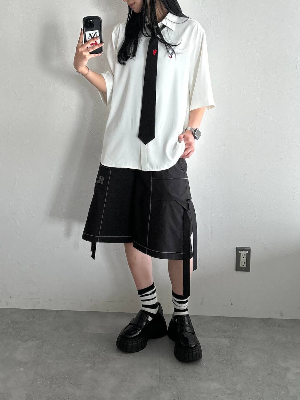 ブラック系のネクタイ、ブラック系のローファー、ホワイト系のシャツ/ブラウスを着用したレディースの春コーディネートの2枚目の写真