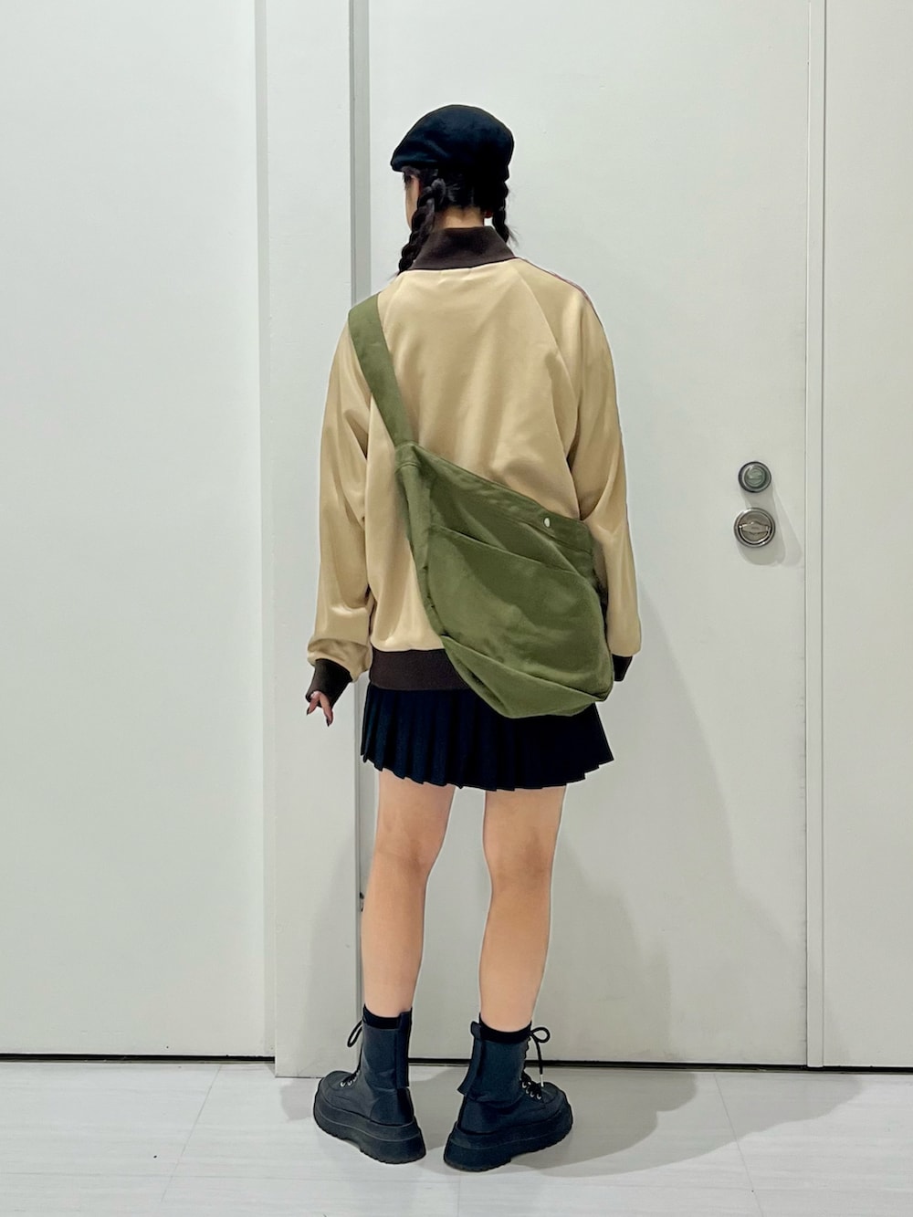 ベージュ系のセットアップ、グリーン系のショルダーバッグ、ブラック系のブーツを着用したレディースの秋コーディネートの4枚目の写真