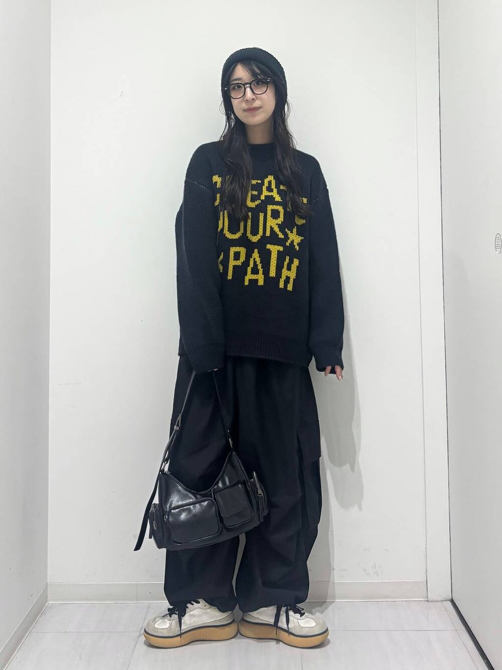 ブラック系のショルダーバッグ、ブラック系のカーゴパンツ、ブルー系のニット/セーターを着用したレディースの秋コーディネートの6枚目の写真