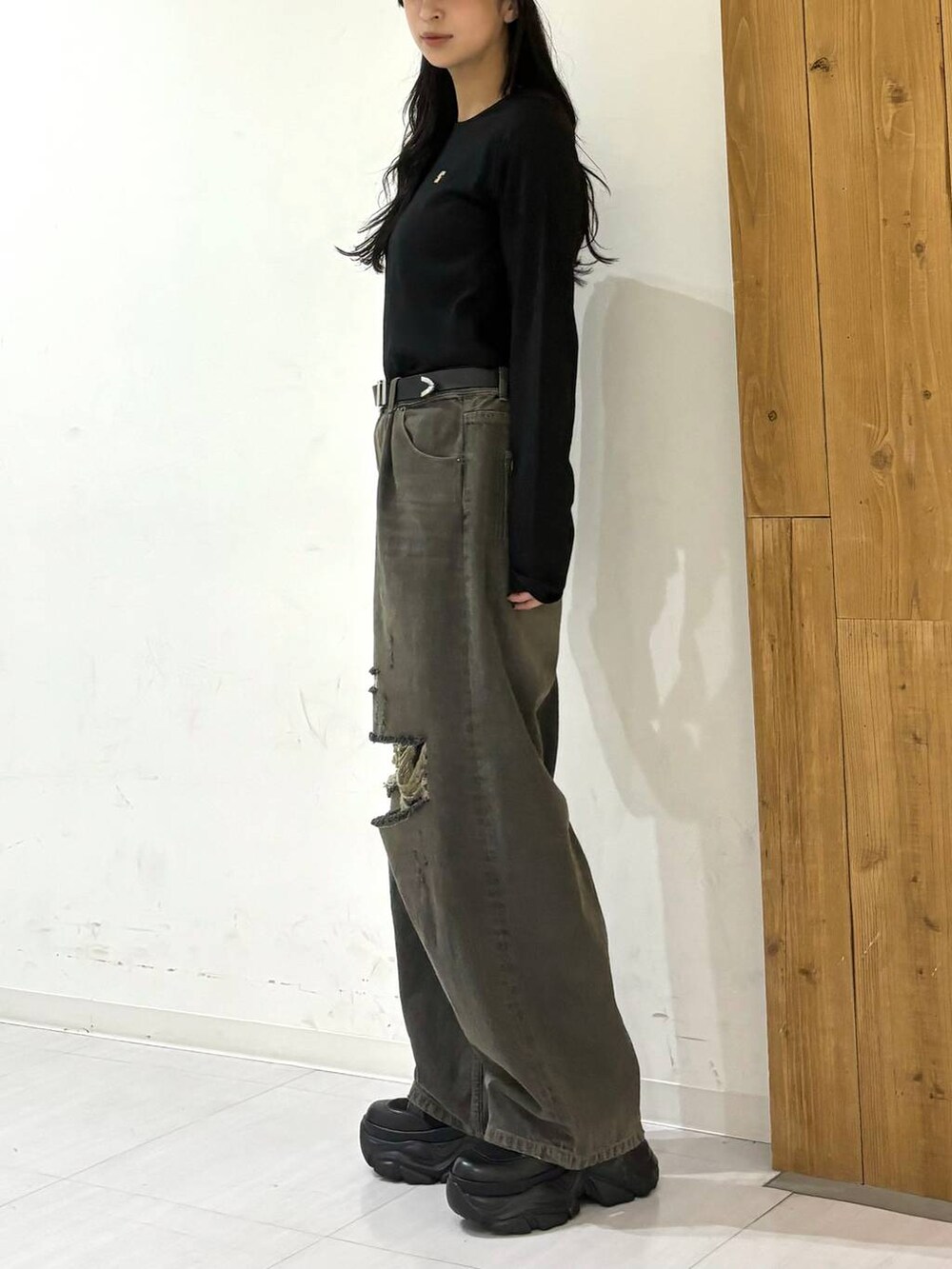 ブラック系のスニーカー、ブラック系のデニムパンツ、ブラック系のTシャツ/カットソーを着用したレディースの秋コーディネートの2枚目の写真