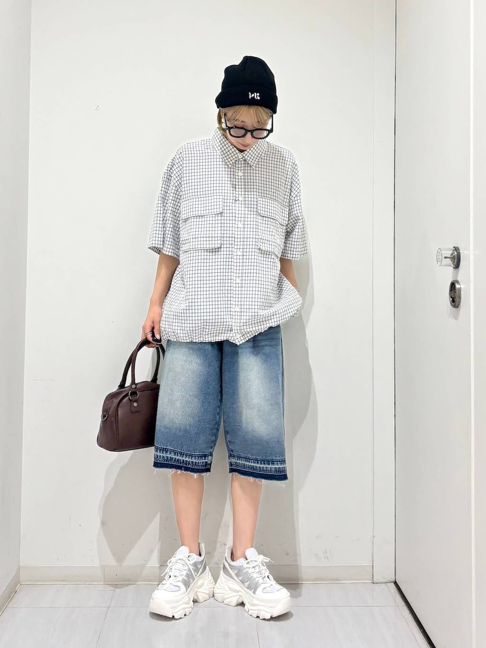 ホワイト系のスニーカー、ブラウン系のショルダーバッグ、ブルー系のデニムパンツを着用したレディースの夏コーディネートの7枚目の写真