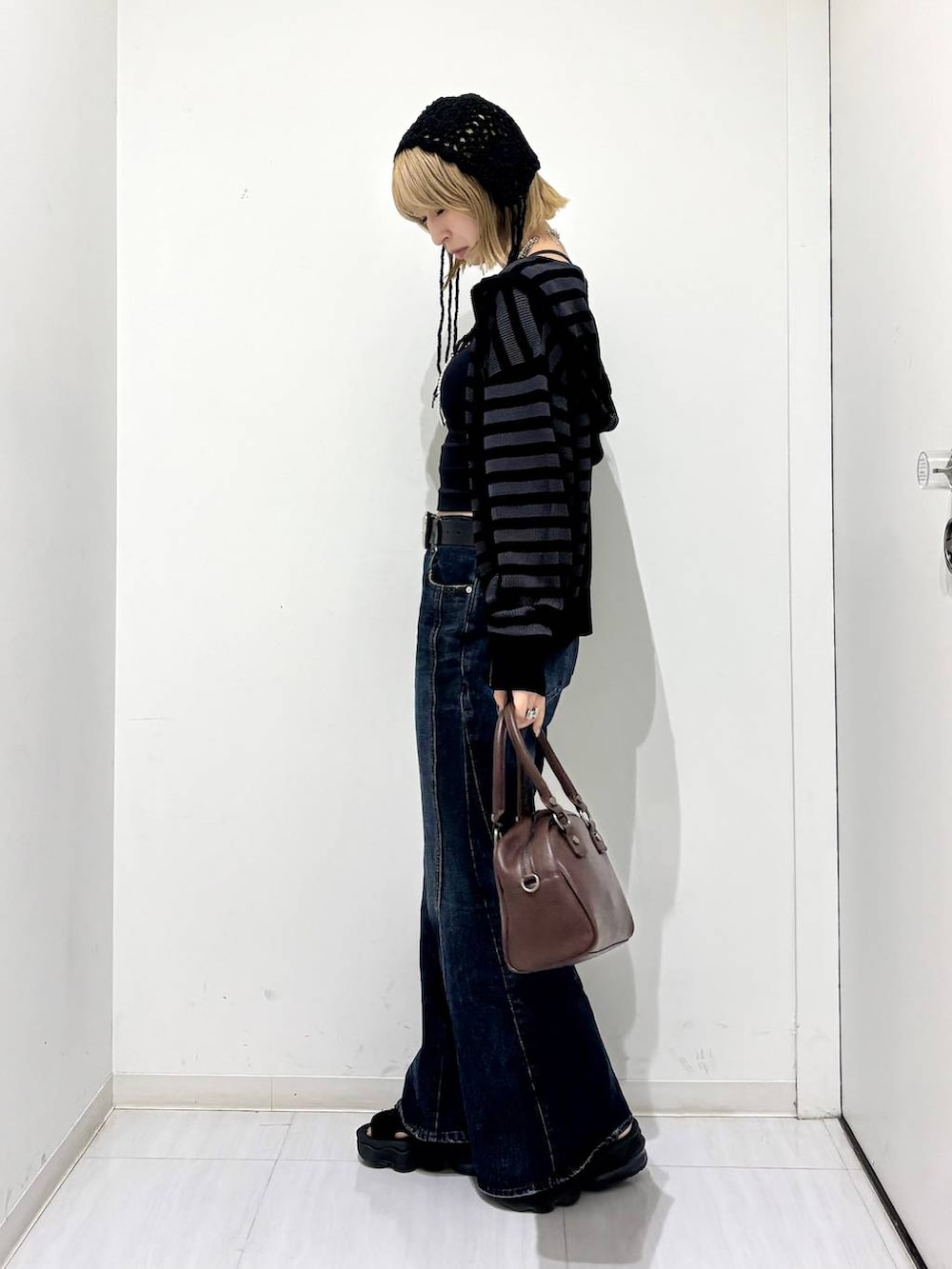 ブラック系のキャミソール、ブラウン系のショルダーバッグ、ブルー系のデニムパンツを着用したレディースの夏コーディネートの2枚目の写真