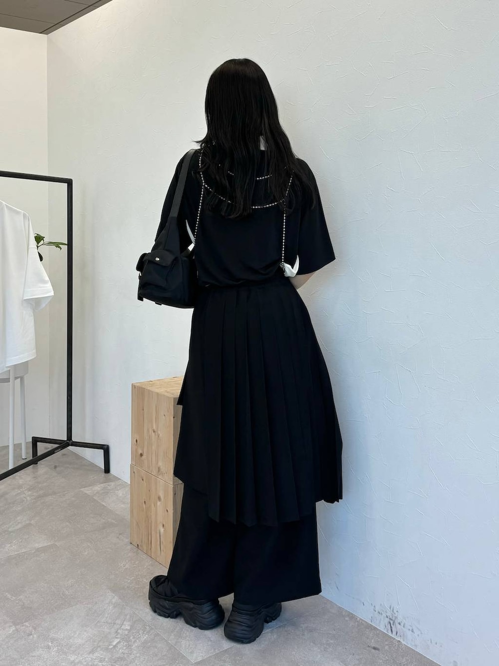 ブラック系のショルダーバッグ、ブラック系のスニーカー、ブラック系のスラックスを着用したレディースの春コーディネートの4枚目の写真