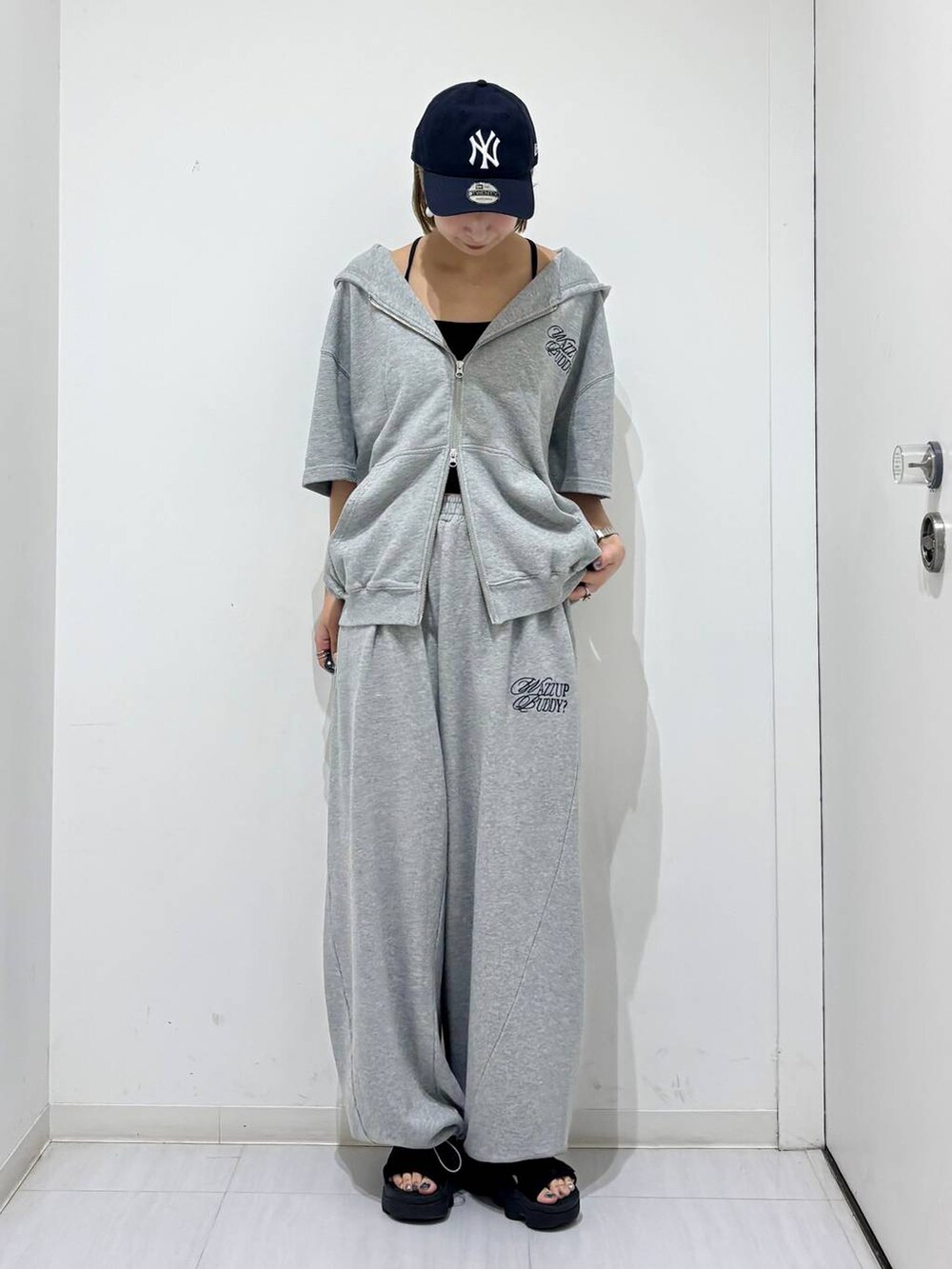 グレー系のスウェットパンツ、グレー系のパーカー、ブルー系のキャップを着用したレディースの夏コーディネートの4枚目の写真