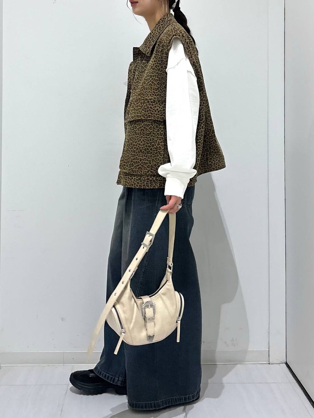 ブルー系のデニムパンツ、ホワイト系のスウェット、ブラック系のスニーカーを着用したレディースの春コーディネートの4枚目の写真