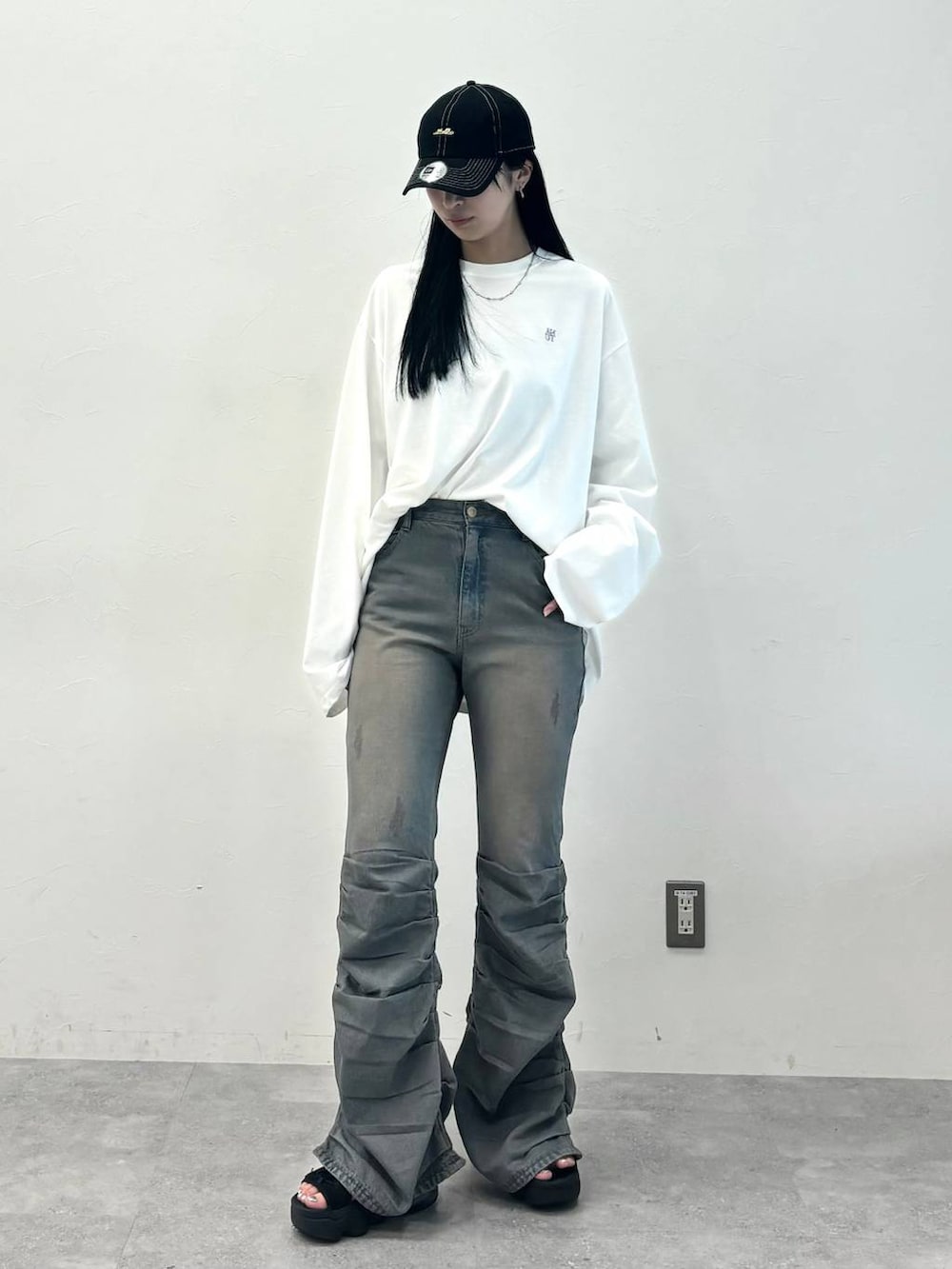 ブルー系のデニムパンツ、ホワイト系のTシャツ/カットソー、ブラック系のキャップを着用したレディースの秋コーディネートの4枚目の写真