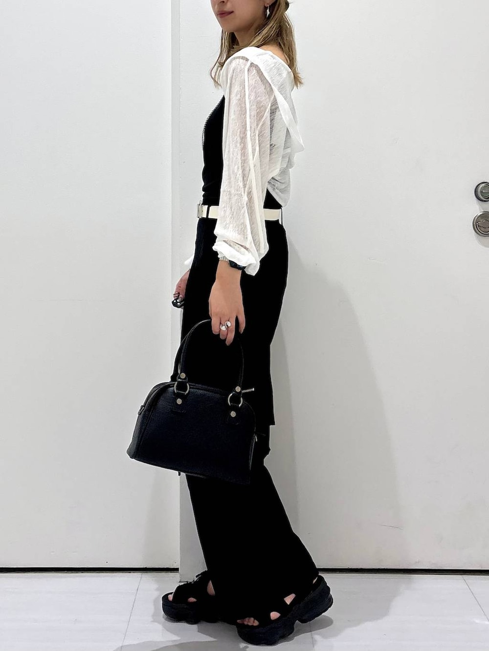 ブラック系のカーゴパンツ、ブラック系のショルダーバッグ、ホワイト系のカーディガン/ボレロを着用したレディースの夏コーディネートの3枚目の写真