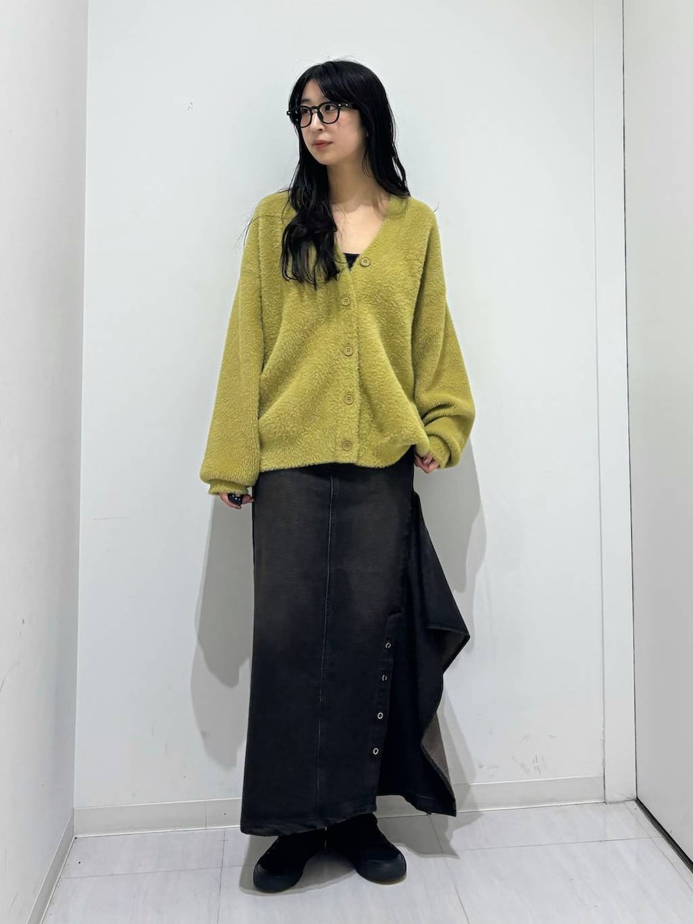 ブラック系のデニムスカート、イエロー系のカーディガン/ボレロを着用したレディースの秋コーディネートの4枚目の写真