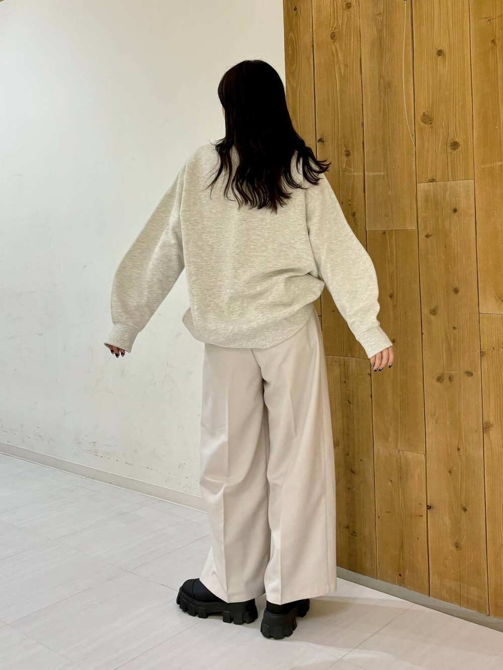 ブラック系のブーツ、ベージュ系のスラックス、ベージュ系のスウェットを着用したレディースの冬コーディネートの6枚目の写真