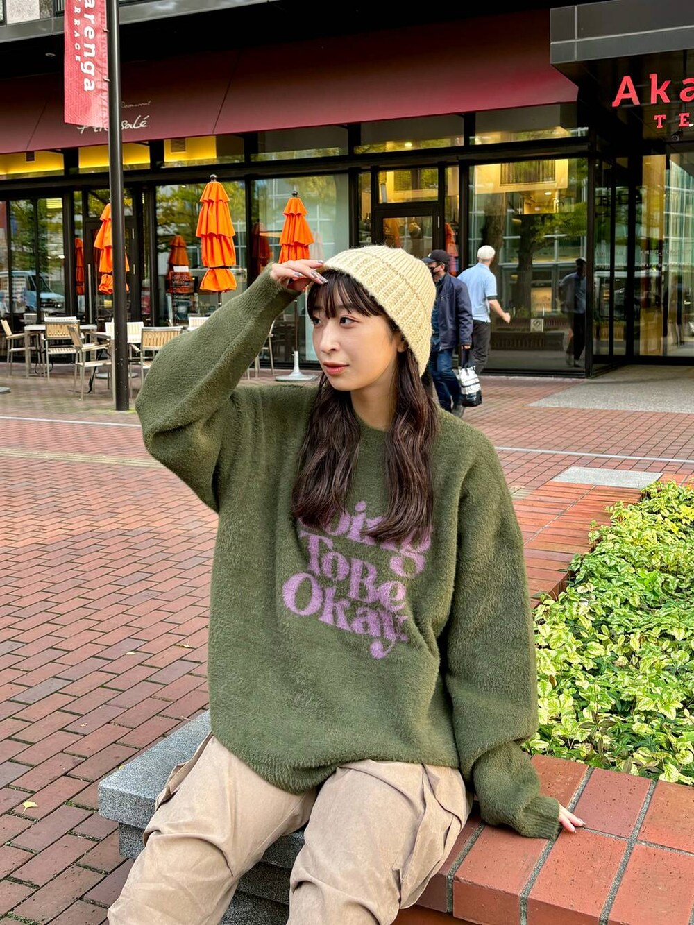 ベージュ系のカーゴパンツ、グリーン系のニット/セーター、ベージュ系のハットを着用したレディースの秋コーディネートの3枚目の写真