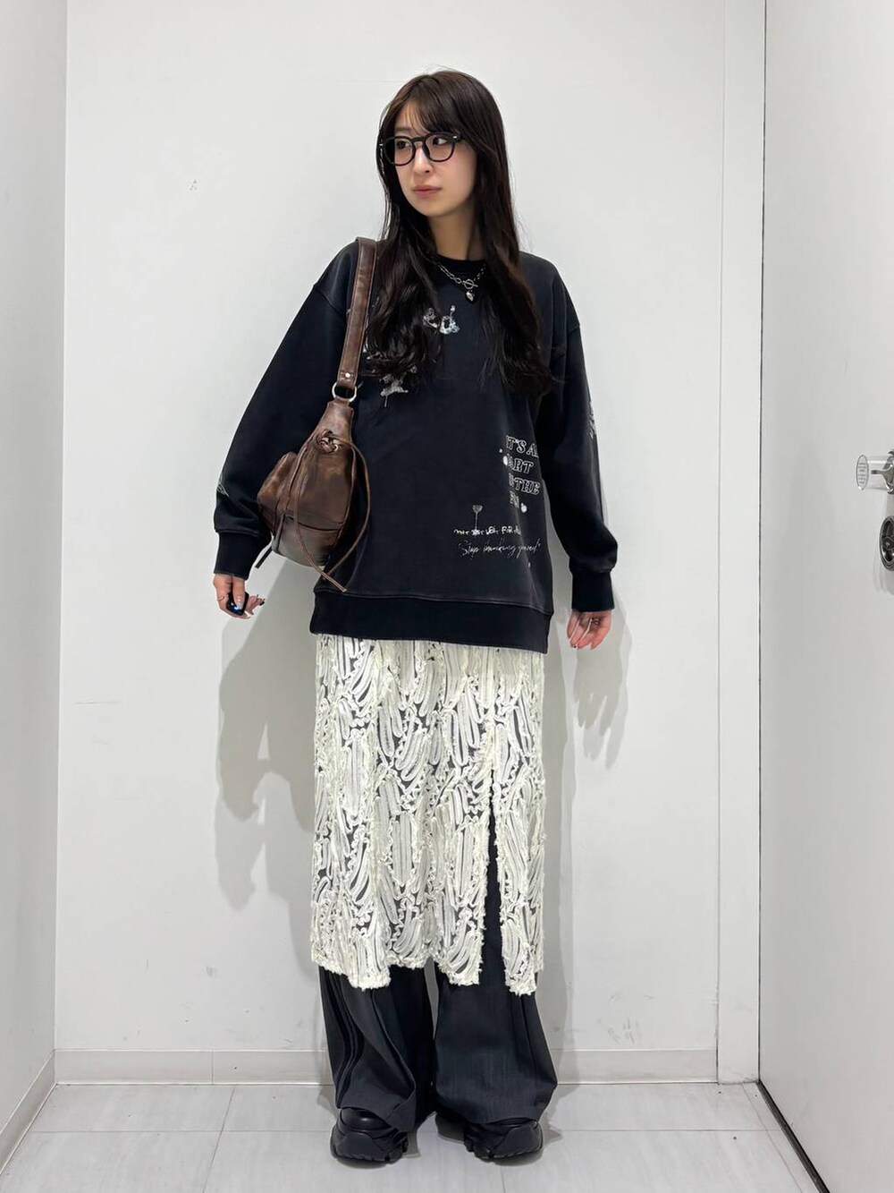 ブラック系のスニーカー、グレー系のスウェット、ブラウン系のショルダーバッグを着用したレディースの冬コーディネートの4枚目の写真