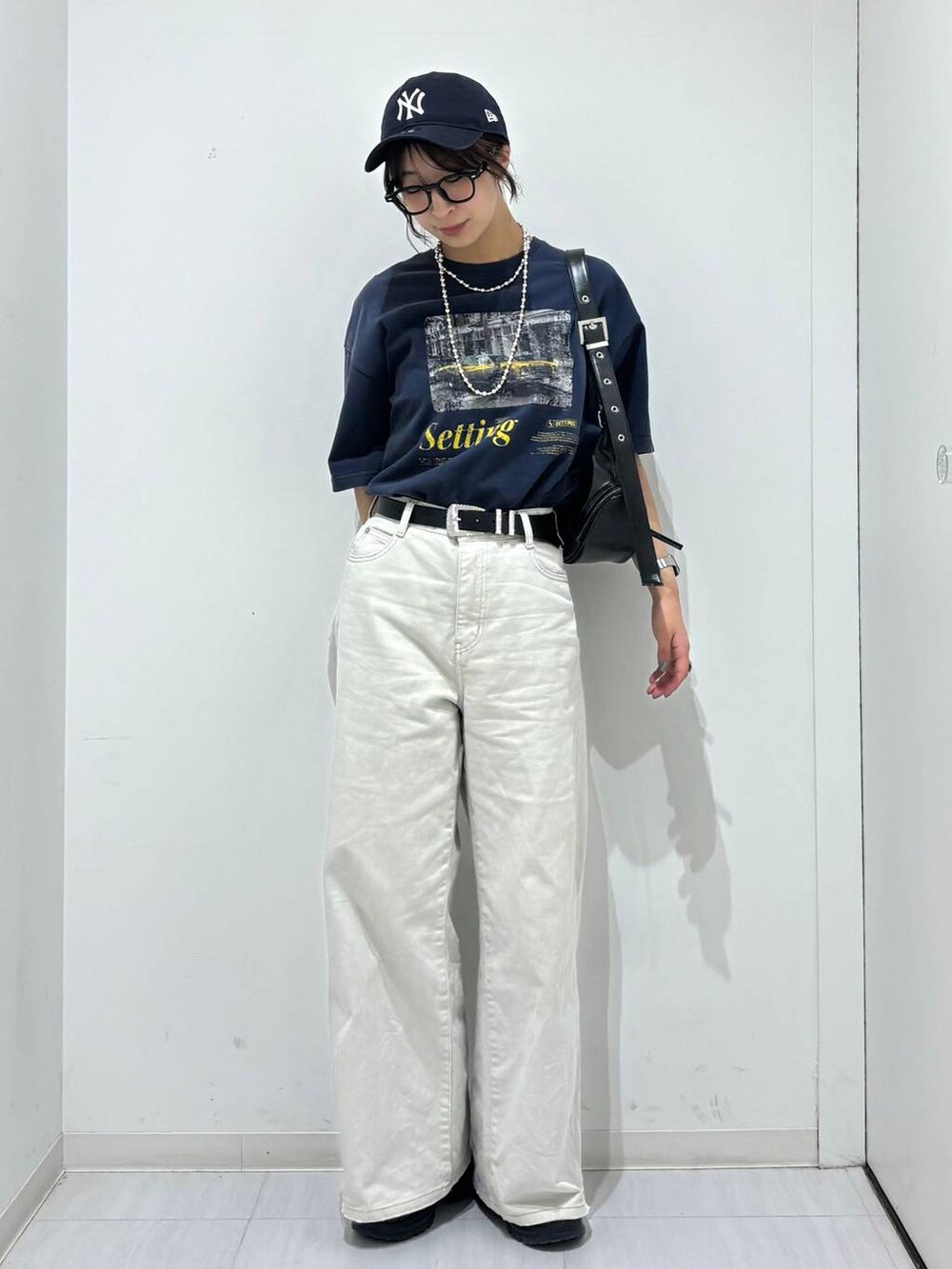 グレー系のデニムパンツ、ブラック系のスニーカー、ブルー系のTシャツ/カットソーを着用したレディースの春コーディネートの6枚目の写真