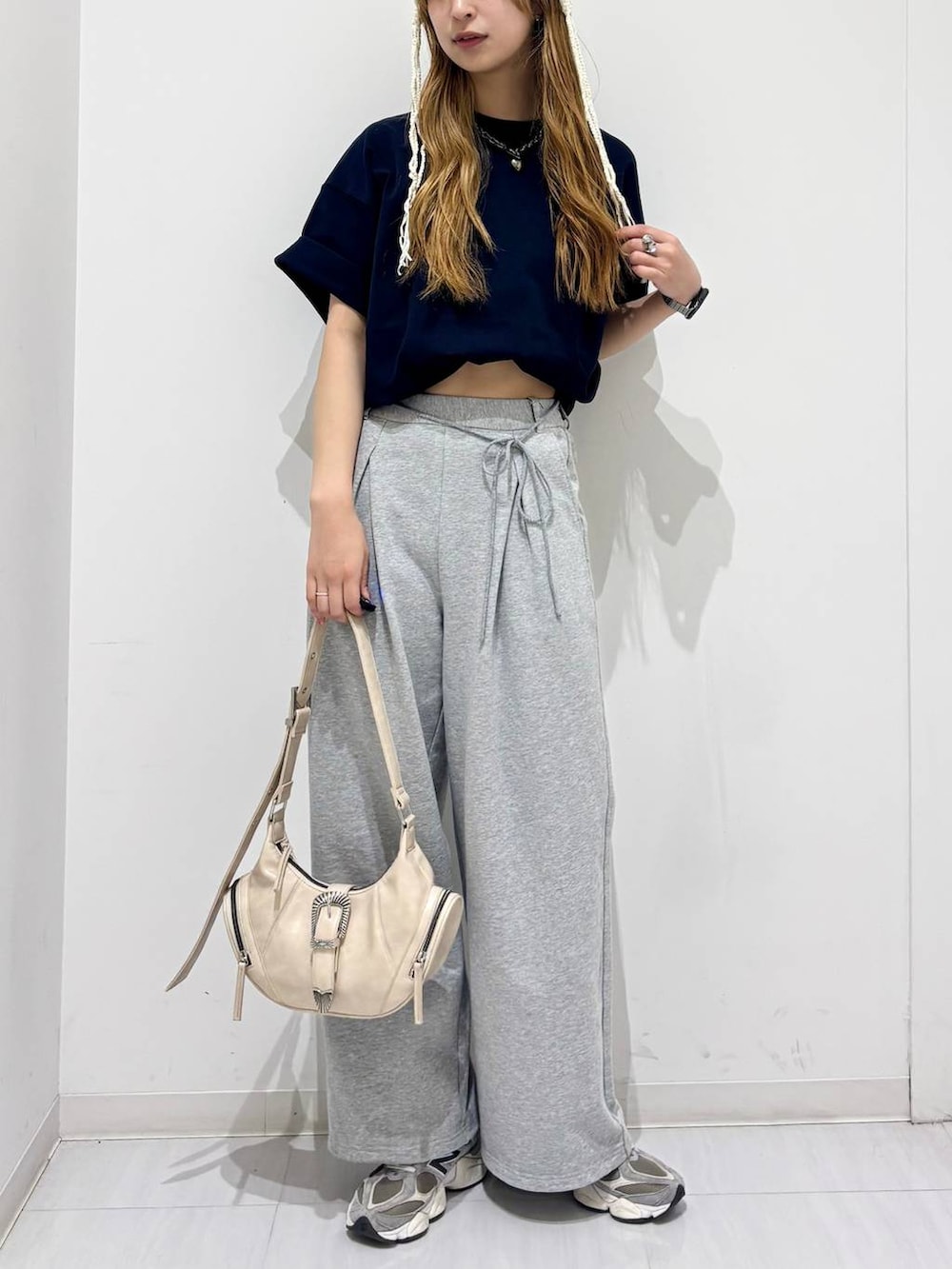 ホワイト系のショルダーバッグ、ブルー系のTシャツ/カットソー、グレー系のスウェットパンツを着用したレディースの春コーディネートの2枚目の写真