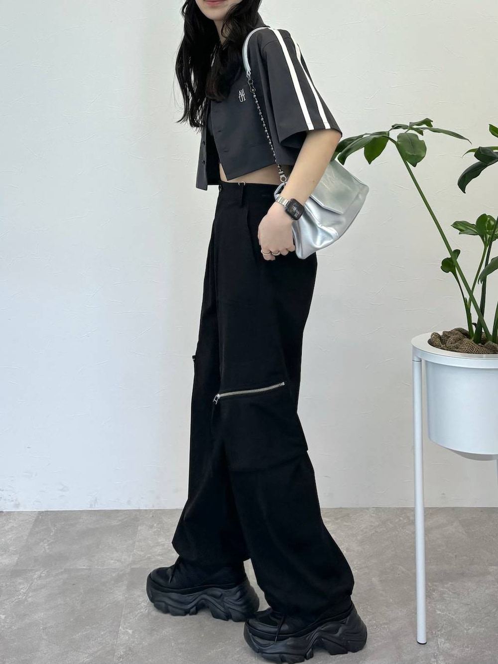 シルバー系のショルダーバッグ、ブラック系のスニーカー、ブラック系のカーゴパンツを着用したレディースの春コーディネートの2枚目の写真